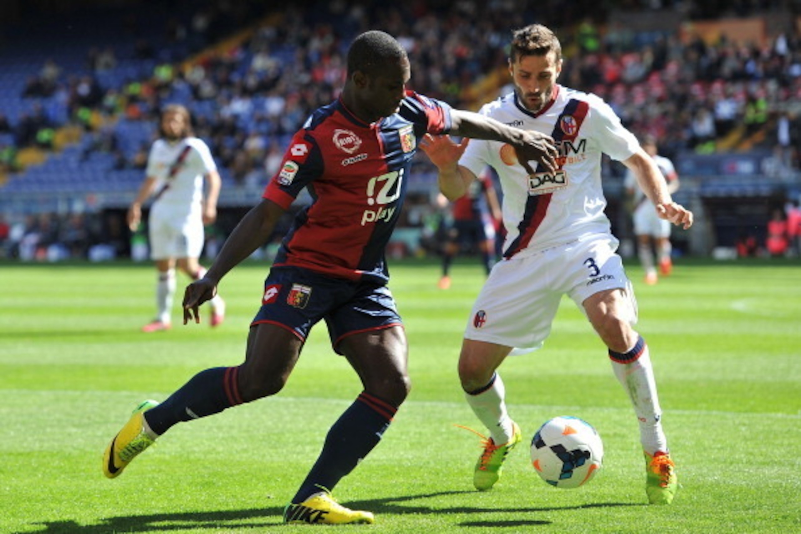 GENOA, ITALY - MAY 04:  Moussa Konate (L) of Genoa CFC is challenged by Archimede Morleo of Bologna FC during the Serie A match between Genoa CFC and Bologna FC at Stadio Luigi Ferraris on May 4, 2014 in Genoa, Italy.  (Photo by Valerio Pennicino/Getty Im
