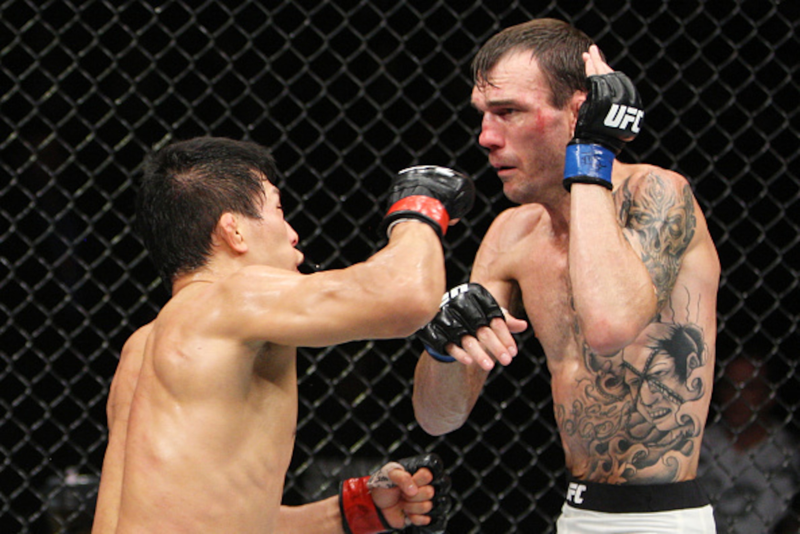 SAITAMA, JAPAN - SEPTEMBER 27:  Takeya Mizugaki of Japan punches George Roop of the United States of America in their bantamweight bout during the UFC event at the Saitama Super Arena on September 27, 2015 in Saitama, Japan. (Photo by Mitch Viquez/Zuffa L