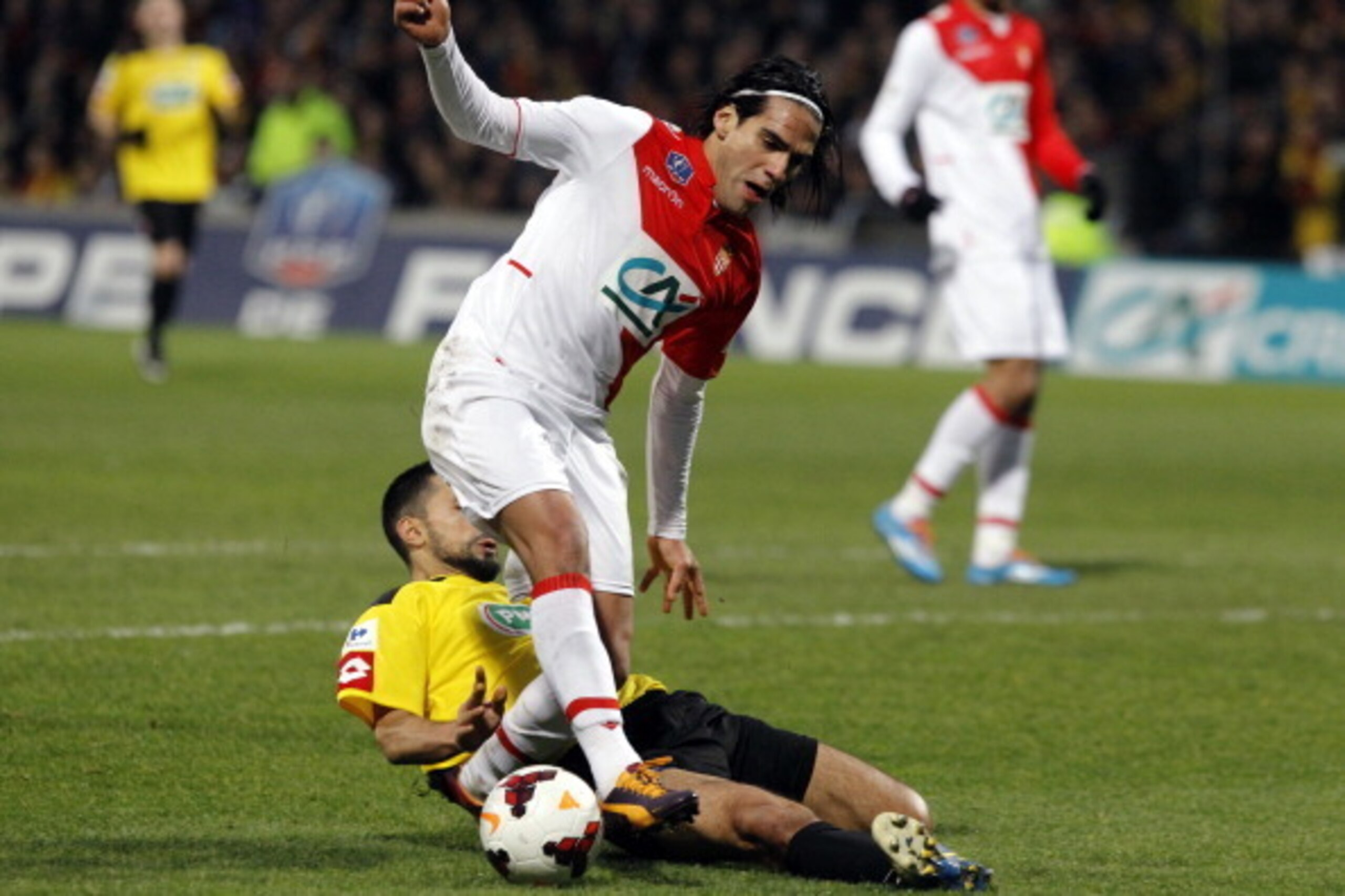 A picture taken on January 22, 2014 shows Monaco's Colombian forward Radamel Falcao (front) being challenged by Chasselay's French defender Soner Ertek during the French Cup football match between Chasselay and Monaco at the Gerland stadium in Lyon. Falca