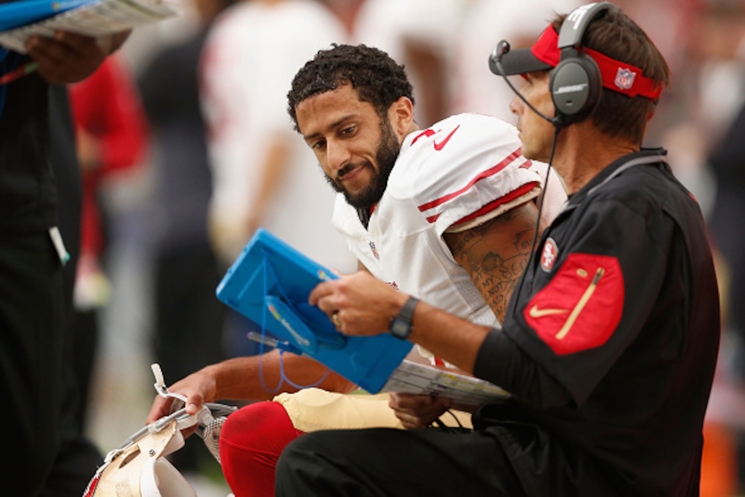 GLENDALE, AZ - SEPTEMBER 27: Quarterback Colin Kaepernick #7 of the San Francisco 49ers looks at a playbook on the sidelines during the NFL game against the Arizona Cardinals at the University of Phoenix Stadium on September 27, 2015 in Glendale, Arizona.