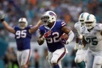 Sep 27, 2015; Miami Gardens, FL, USA; Preston Brown (52) runs to score with this interception as Miami Dolphins guard Jamil Douglas (75) chases in the 2nd quarter at Sun Life Stadium. Mandatory Credit: Andrew Innerarity-USA TODAY Sports