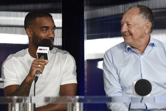 Lyon's French forward Alexandre Lacazette (L) speaks with Lyon's president Jean-Michel Aulas (R) during a press conference on August 8, 2015 in Lyon, southeastern France.  AFP PHOTO / PHILIPPE DESMAZES        (Photo credit should read PHILIPPE DESMAZES/AF