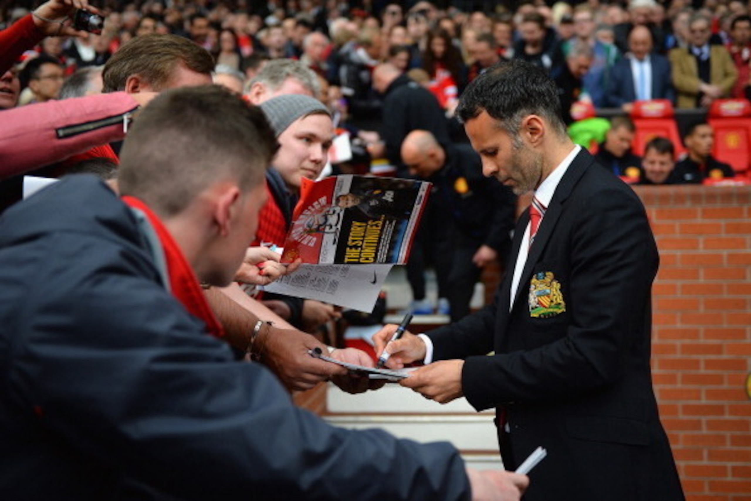 MANCHESTER, ENGLAND - APRIL 26:  Ryan Giggs of Manchester United signs autographs during the Barclays Premier League match between Manchester United and Norwich City at Old Trafford on April 26, 2014 in Manchester, England.  (Photo by Laurence Griffiths/G