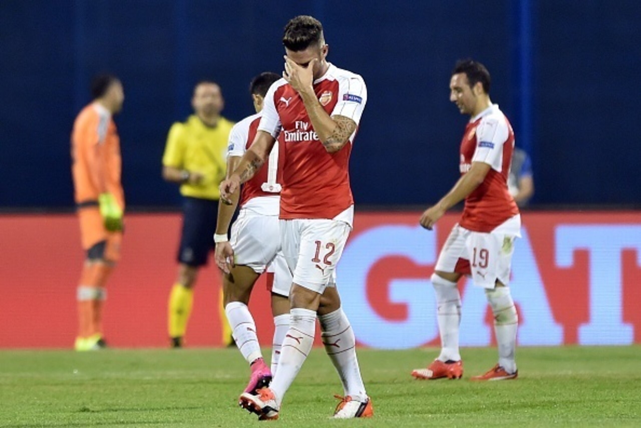 Arsenal's French forward Olivier Giroud (L) leaves the pitch after receiving the second yellow car during the UEFA Champions League Group F football match between GNK Dinamo Zagreb and Arsenal FC at Maksimir Stadium in Zagreb on September 16, 2015.  AFP P