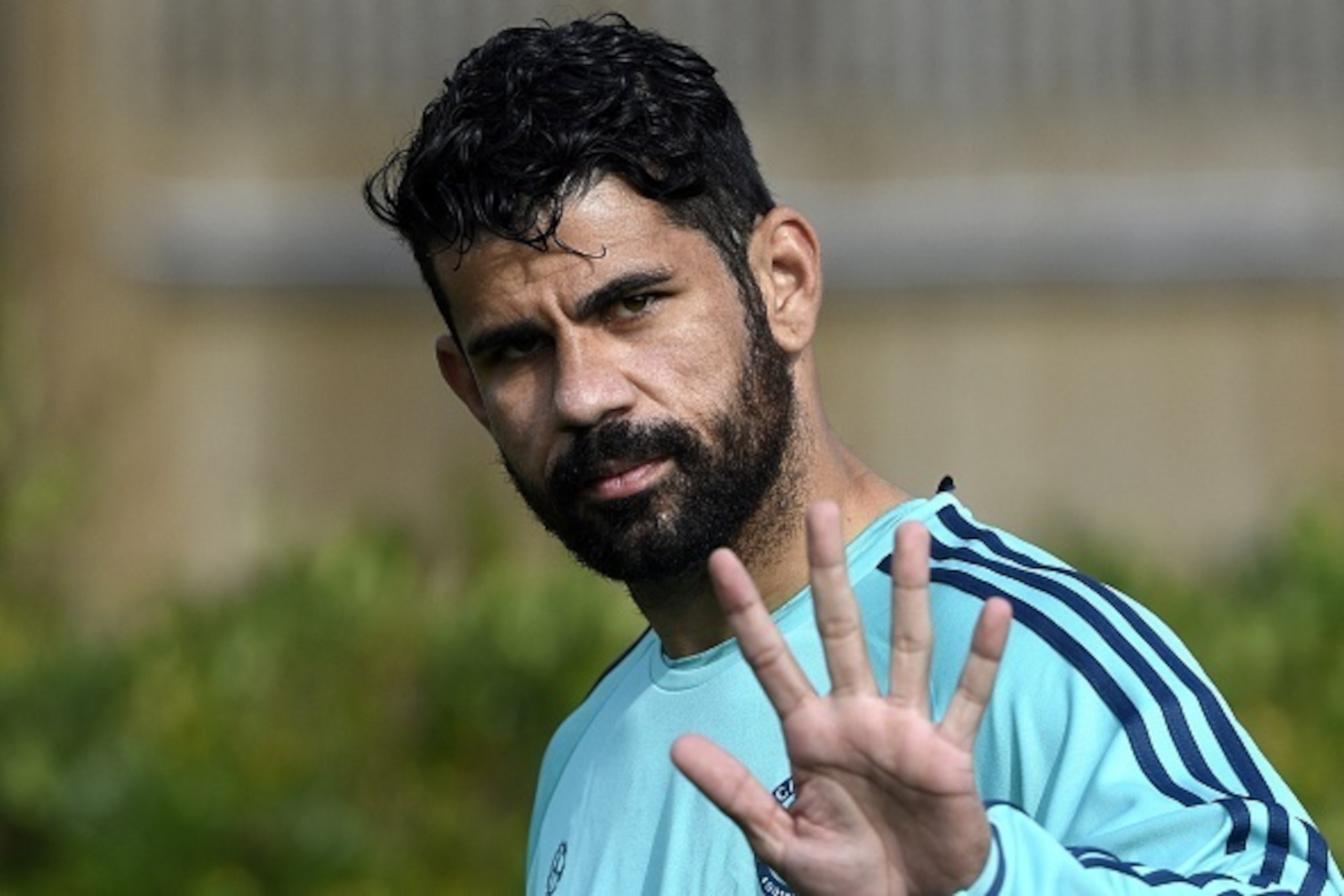 Chelsea's Brazilian-born Spanish striker Diego Costa waves as he arrives for a training session at Chelsea's training ground in Stoke D'Abernon, south of London, on September 28, 2015, on the eve of their UEFA Champions League Group G football match again