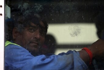 A foreign laborer working on the construction site of the al-Wakrah football stadium, one of the Qatar's 2022 World Cup stadiums, sits in a bus as he comes back to his accomodation at the Ezdan 40 compound after finishing work on May 4, 2015, in Doha's Al