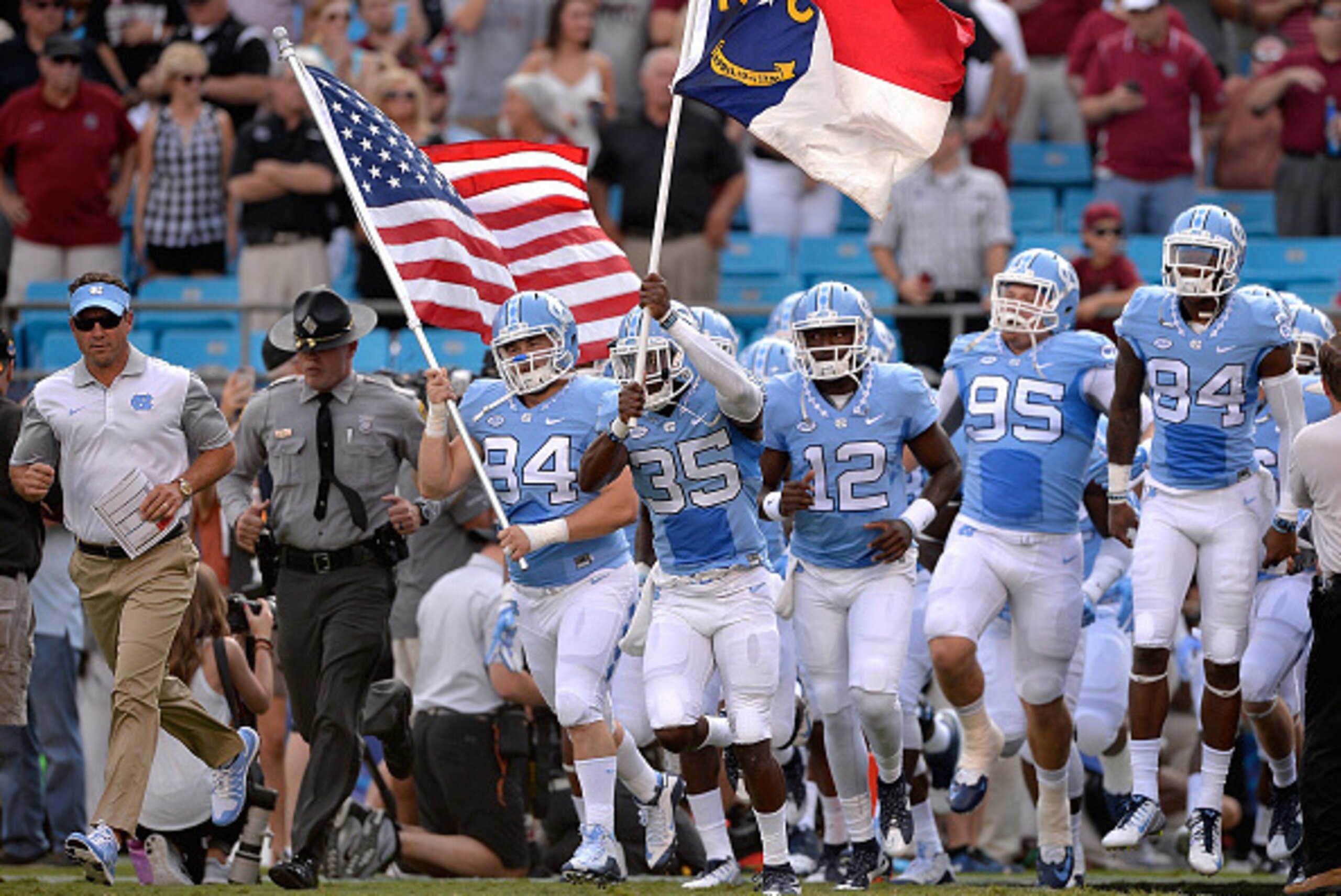 CHARLOTTE, NC - SEPTEMBER 03:  Head coach Larry Fedora of the North Carolina Tar Heels  leads his team onto the field for their game against the South Carolina Gamecocks at Bank of America Stadium on September 3, 2015 in Charlotte, North Carolina. South C