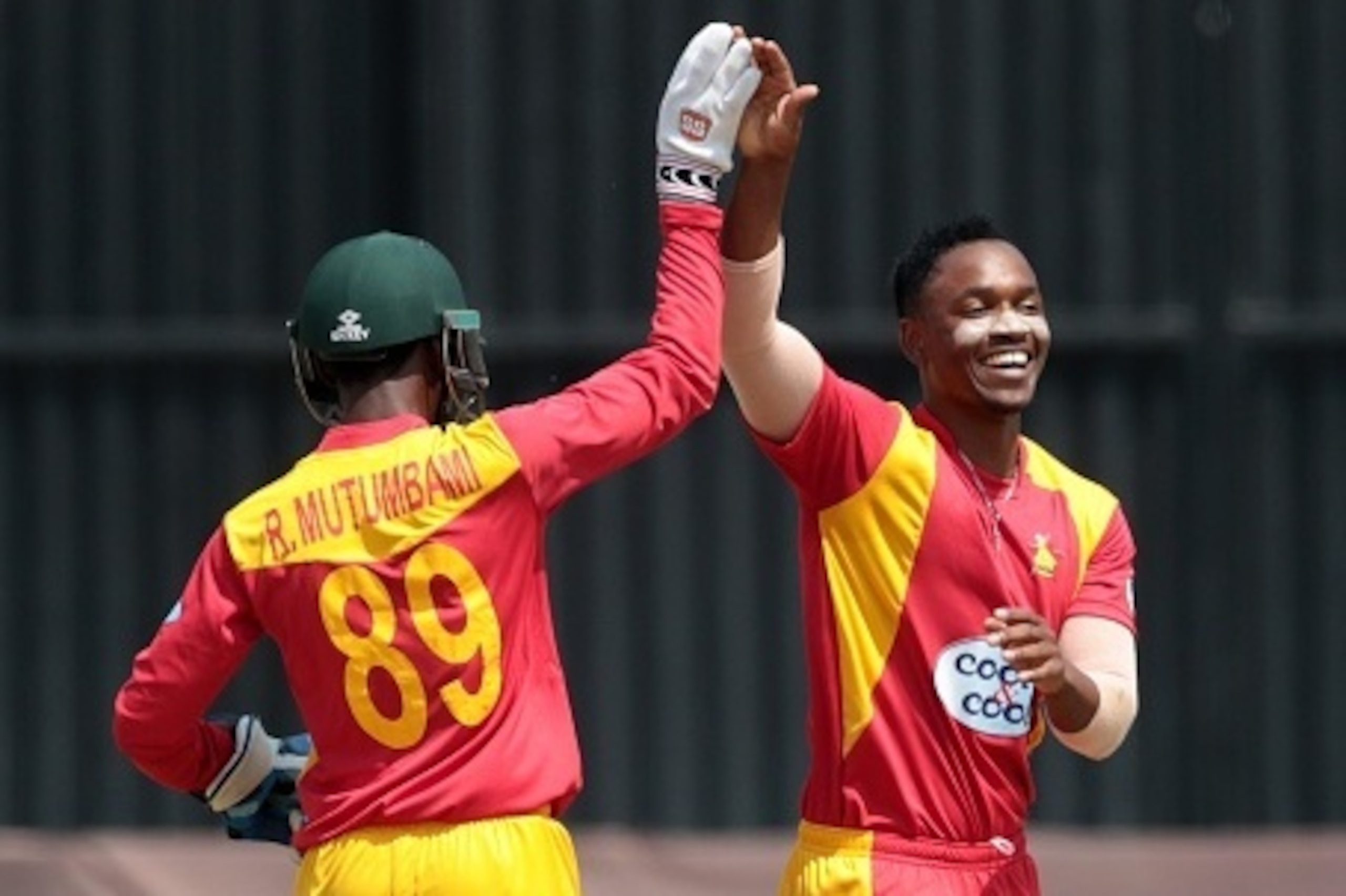 Zimbabwe bowler Chamunorwa Chibhabha (R) celebrates a wicket with wicket keeper Richmond Mutumbami (L) in action during the first of two T20 cricket matches between Pakistan and hosts Zimbabwe at Harare Sports Club,  September 27, 2015. AFP PHOTO / JEKESA