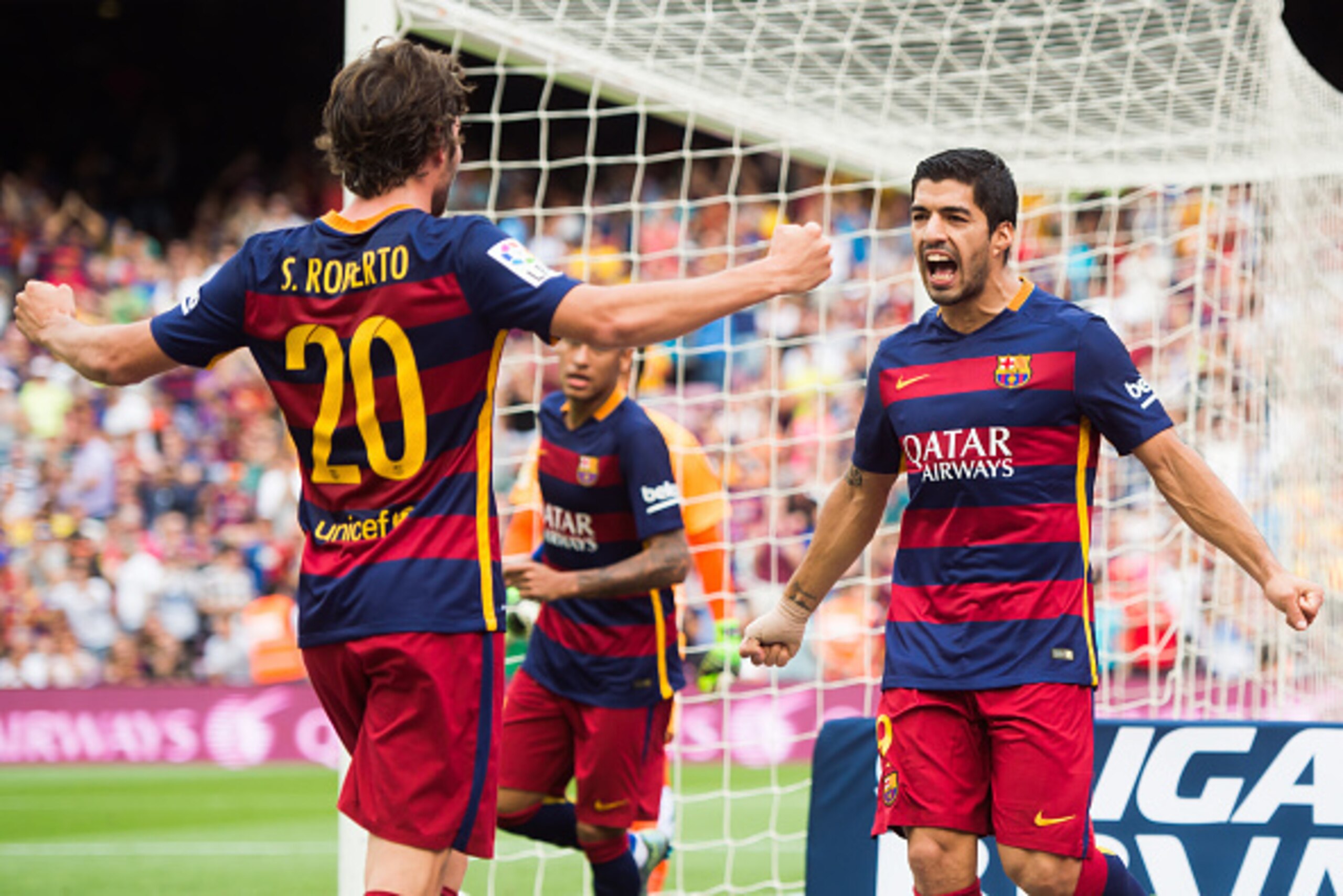 BARCELONA, SPAIN - SEPTEMBER 26: Luis Suarez (R) of FC Barcelona celebrates with his teammate Sergi Roberto (L) after scoring the opening goal during the La Liga match between FC Barcelona and UD Las Palmas at Camp Nou on September 26, 2015 in Barcelona, 