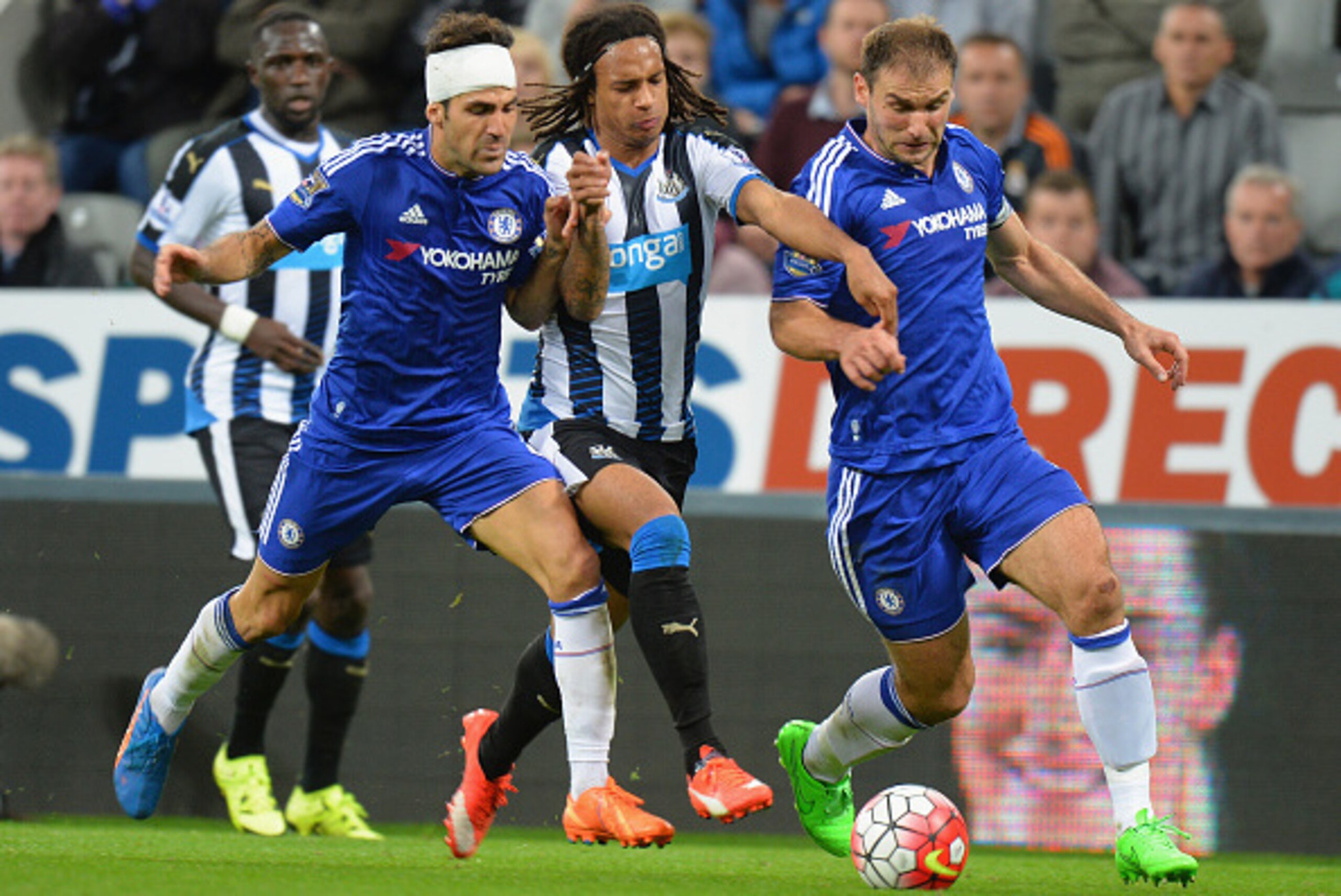 NEWCASTLE UPON TYNE, ENGLAND - SEPTEMBER 26:  Kevin Nbabu (C)of Newcastle United competes against Sesc Fabregas (L) and Branislav Ivanovic (R) of Chelsea  during the Barclays Premier League match between Newcastle United and Chelsea at St James' Park on S