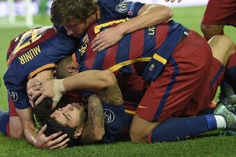 Barcelona's Uruguayan forward Luis Suarez (bottom) celebrates a goal with teammates during the UEFA Champions League football match FC Barcelona vs Bayer Leverkusen at the Camp Nou stadium in Barcelona on September 29, 2015. AFP PHOTO / LLUIS GENE        