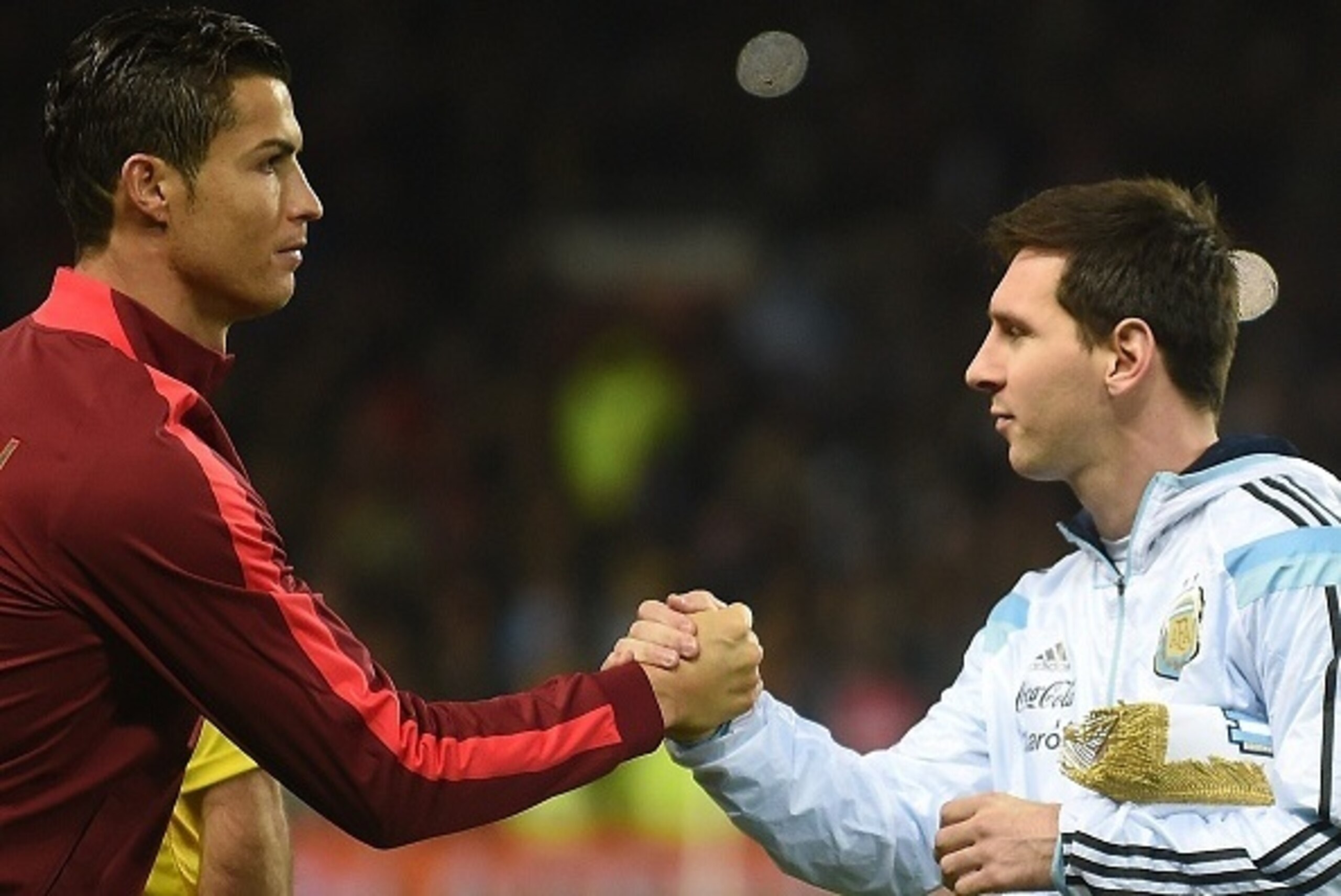 Argentina striker Lionel Messi (R) shakes hands with Portugal's striker Cristiano Ronaldo (L) ahead of kick off of the international friendly football match between the Argentina and Portugal at Old Trafford in Manchester on November 18, 2014. AFP PHOTO /