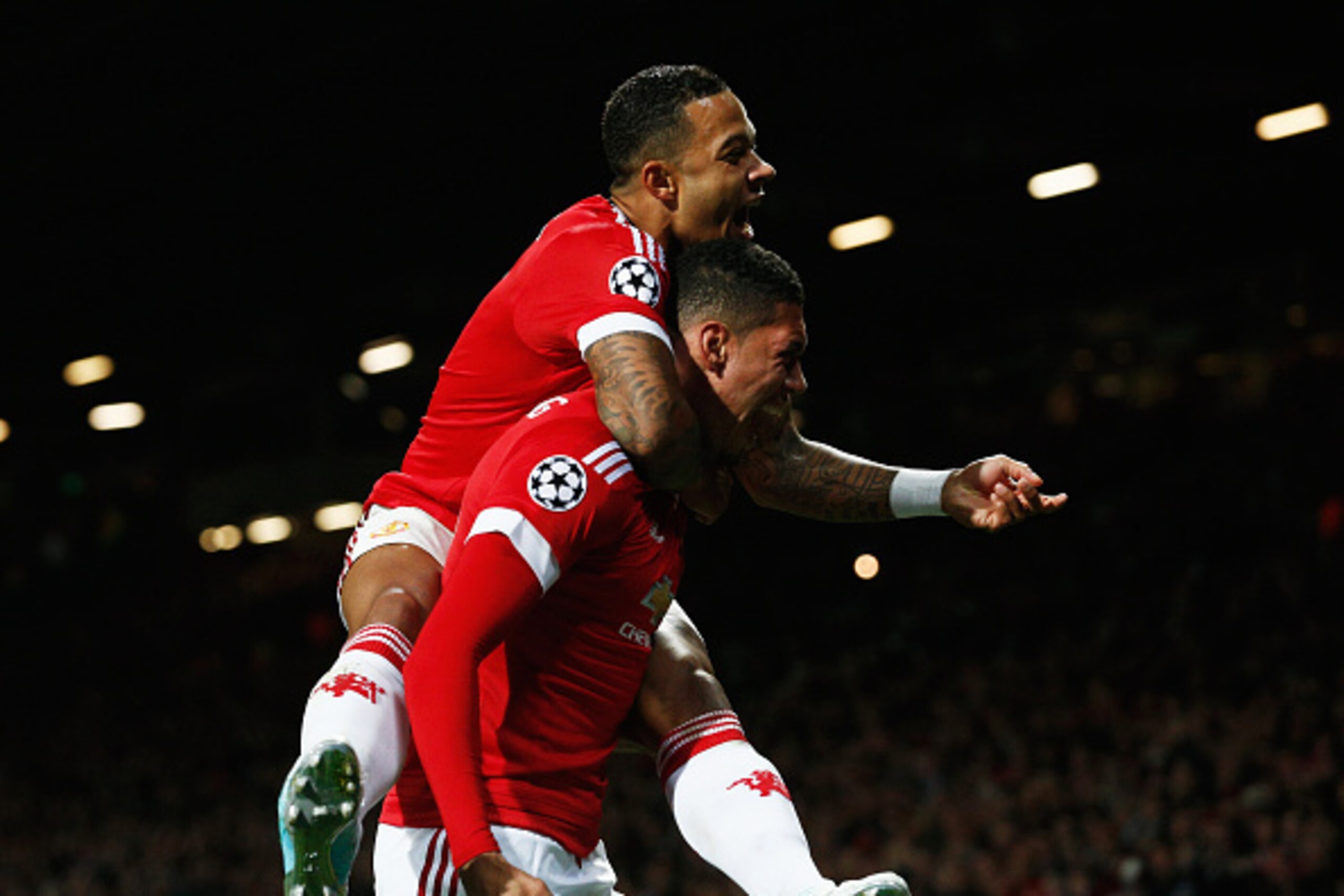 MANCHESTER, ENGLAND - SEPTEMBER 30:  Chris Smalling of Manchester United (R) celebrates with team mate Memphis Depay as he scores their second goal during the UEFA Champions League Group B match between Manchester United FC and VfL Wolfsburg at Old Traffo