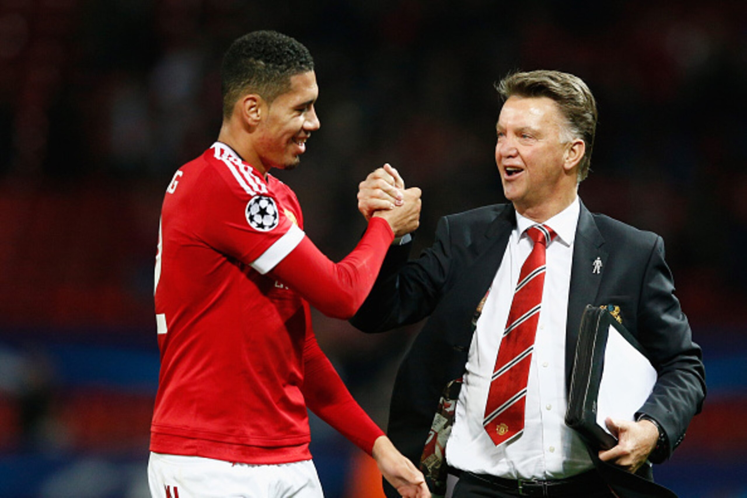 MANCHESTER, ENGLAND - SEPTEMBER 30:  Louis van Gaal manager of Manchester United celebrates victory with winning goalscorer Chris Smalling in the UEFA Champions League Group B match between Manchester United FC and VfL Wolfsburg at Old Trafford on Septemb