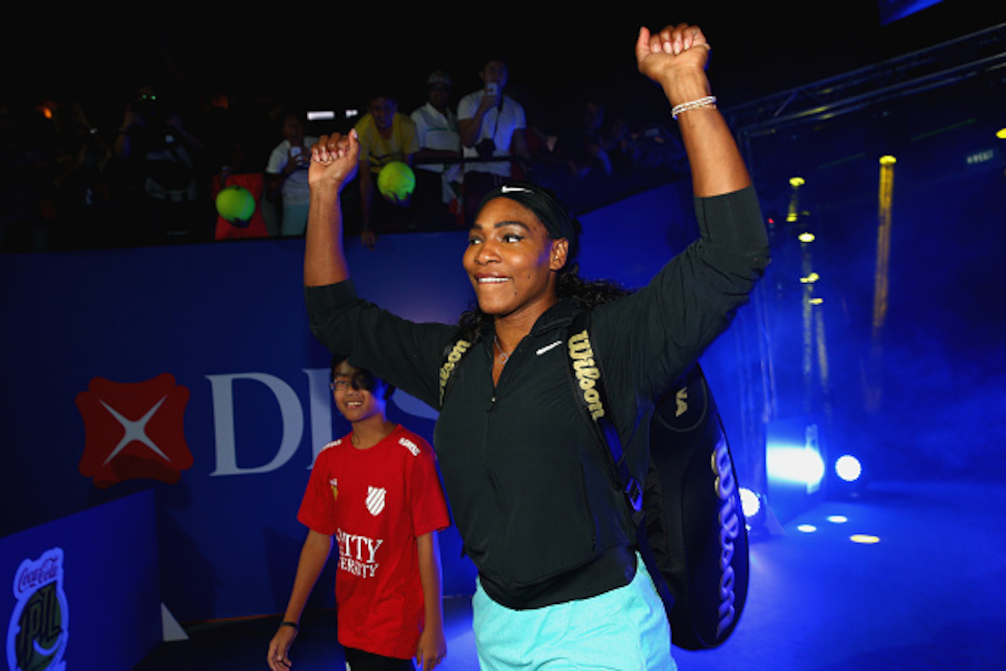SINGAPORE - DECEMBER 02:  Serena Williams of the Singapore Slammers waves to the crowd as she walks out on to court to play against the Manila Mavericks during the Coca-Cola International Premier Tennis League at the Singapore Sports Hub on December 2, 20