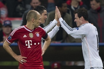 Bayern Munich's Dutch midfielder Arjen Robben (L) watches as Real Madrid's Welsh forward Gareth Bale (R) congratulates Real Madrid's Portuguese forward Cristiano Ronaldo on scoring the 0-4 goal during the UEFA Champions League second-leg semi-final footba
