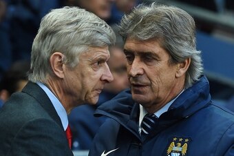 Manchester City's Chilean manager Manuel Pellegrini (R) greets Arsenal's French manager Arsene Wenger (L) as they arrive for the English Premier League football match between Manchester City and Arsenal at the Etihad Stadium in Manchester, north west Engl