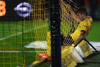 Dortmund's striker Marco Reus struggles in the goal net during the UEFA Europa League second-leg play-off match between Borussia Dortmund and Odds BK in Dortmund on August 28, 2015. Dortmund won the match 7-2. AFP PHOTO / PATRIK STOLLARZ        (Photo cre