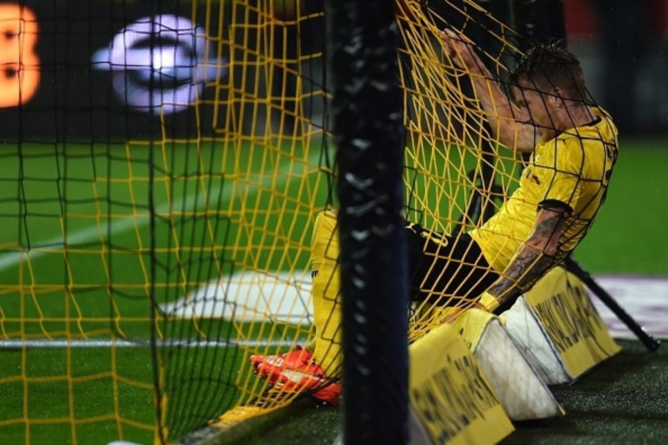 Dortmund's striker Marco Reus struggles in the goal net during the UEFA Europa League second-leg play-off match between Borussia Dortmund and Odds BK in Dortmund on August 28, 2015. Dortmund won the match 7-2. AFP PHOTO / PATRIK STOLLARZ        (Photo cre
