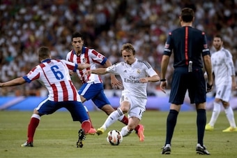 Real Madrid's Croatian midfielder Luka Modric (C) vies with Atletico Madrid's midfielder Koke (L) and Atletico Madrid's Mexican forward Raul Jimenez (2nd L) during the Spanish league football match Real Madrid CF vs Club Atletico de Madrid at the Santiago