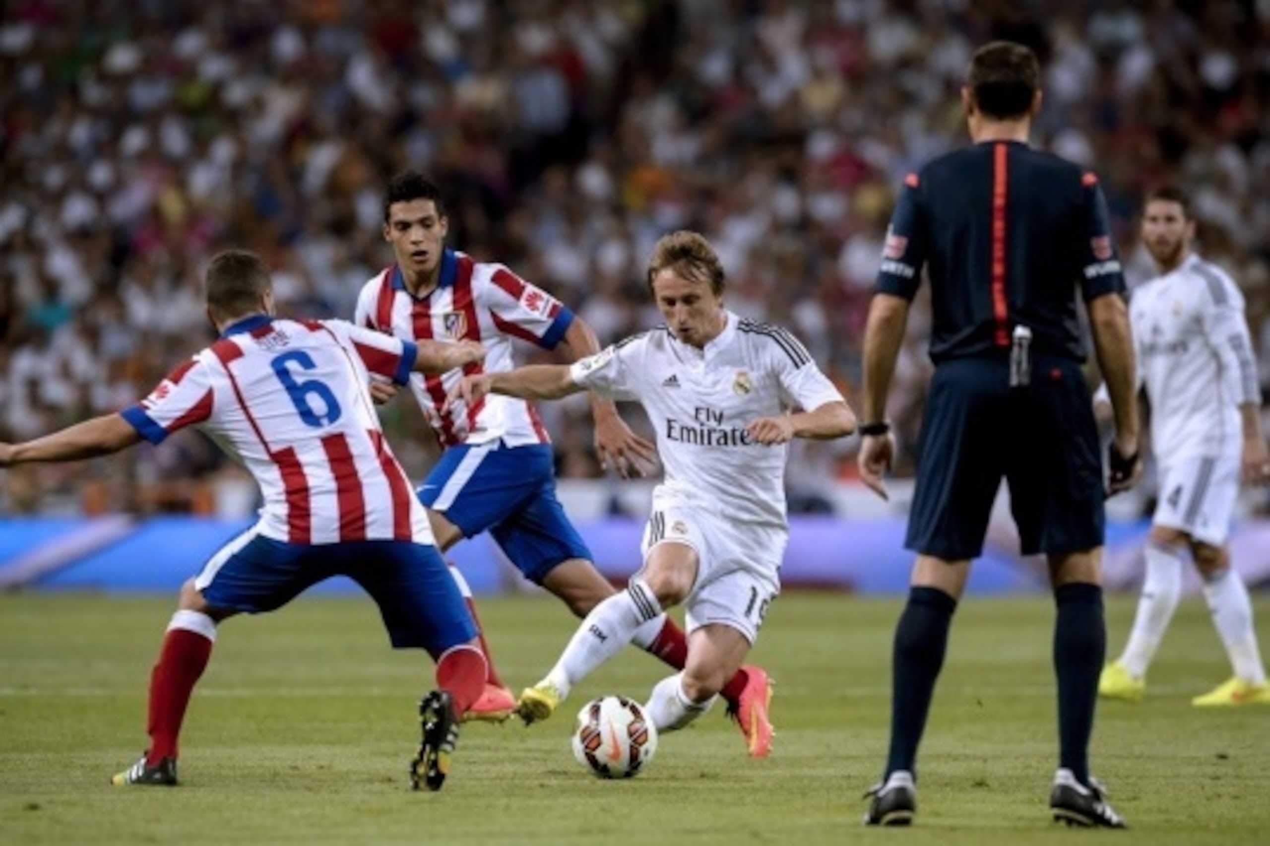 Real Madrid's Croatian midfielder Luka Modric (C) vies with Atletico Madrid's midfielder Koke (L) and Atletico Madrid's Mexican forward Raul Jimenez (2nd L) during the Spanish league football match Real Madrid CF vs Club Atletico de Madrid at the Santiago
