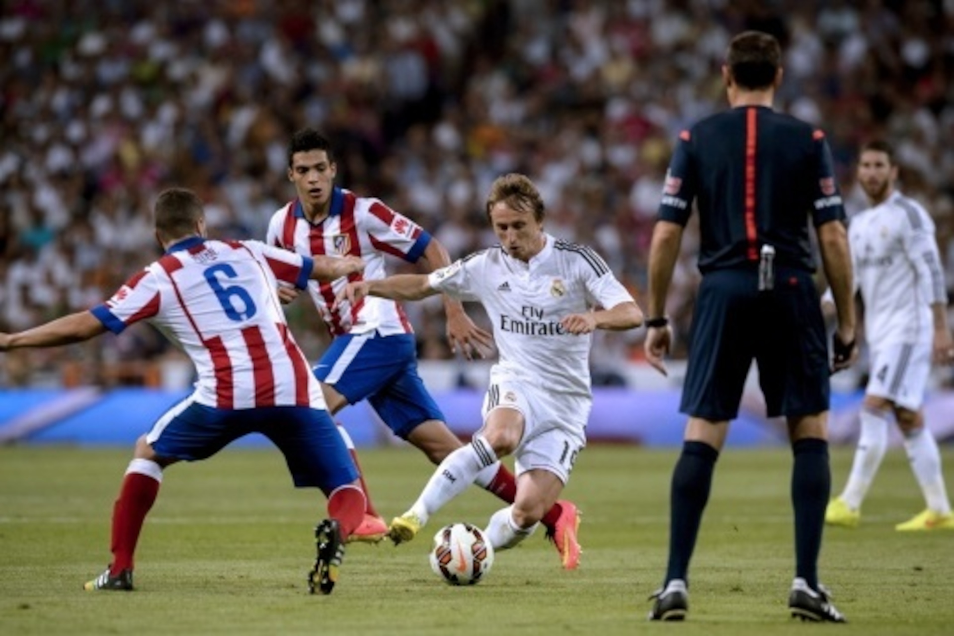 Real Madrid's Croatian midfielder Luka Modric (C) vies with Atletico Madrid's midfielder Koke (L) and Atletico Madrid's Mexican forward Raul Jimenez (2nd L) during the Spanish league football match Real Madrid CF vs Club Atletico de Madrid at the Santiago