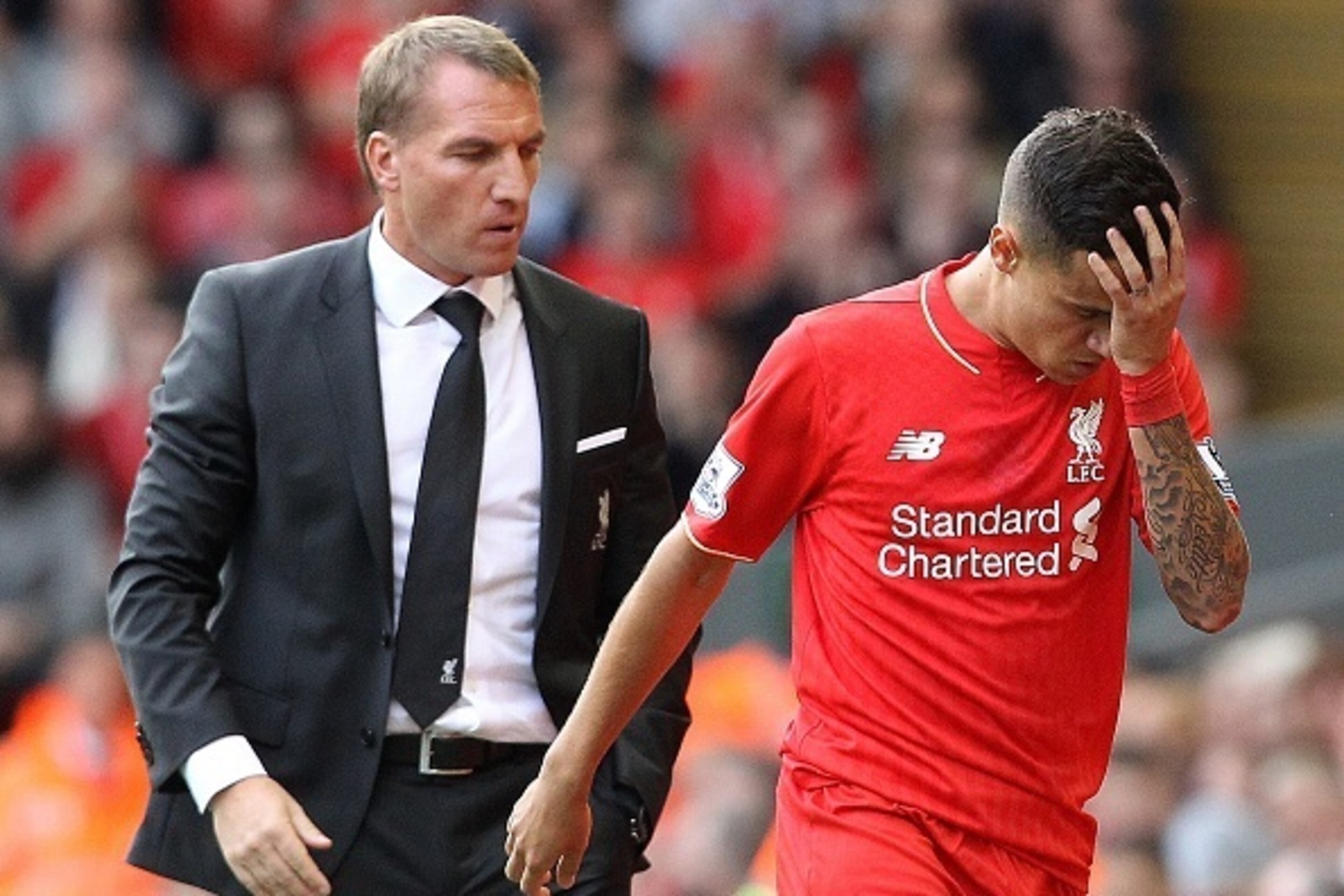 Liverpool's Brazilian midfielder Philippe Coutinho (R) leaves the field after receiving red card, as manager Brendan Rogers looks on, during the English Premier League football match between Liverpool and West Ham at the Anfield stadium in Liverpool, nort