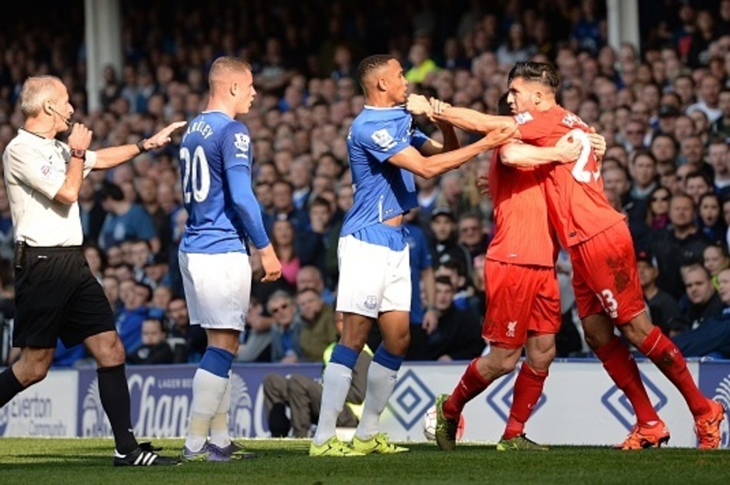 Liverpool's English midfielder James Milner (2R) holds Liverpool's German midfielder Emre Can (R) back from Everton's Zimbabwean midfielder Brendan Galloway (C) and Everton's English midfielder Ross Barkley (2L) as English referee Martin Atkinson approach