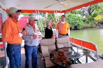 Caldwell (far right) sometimes entertains friends on his houseboat. (From left) Gary Moffatt, Len Johnson and Edna Johnson chat with Caldwell.