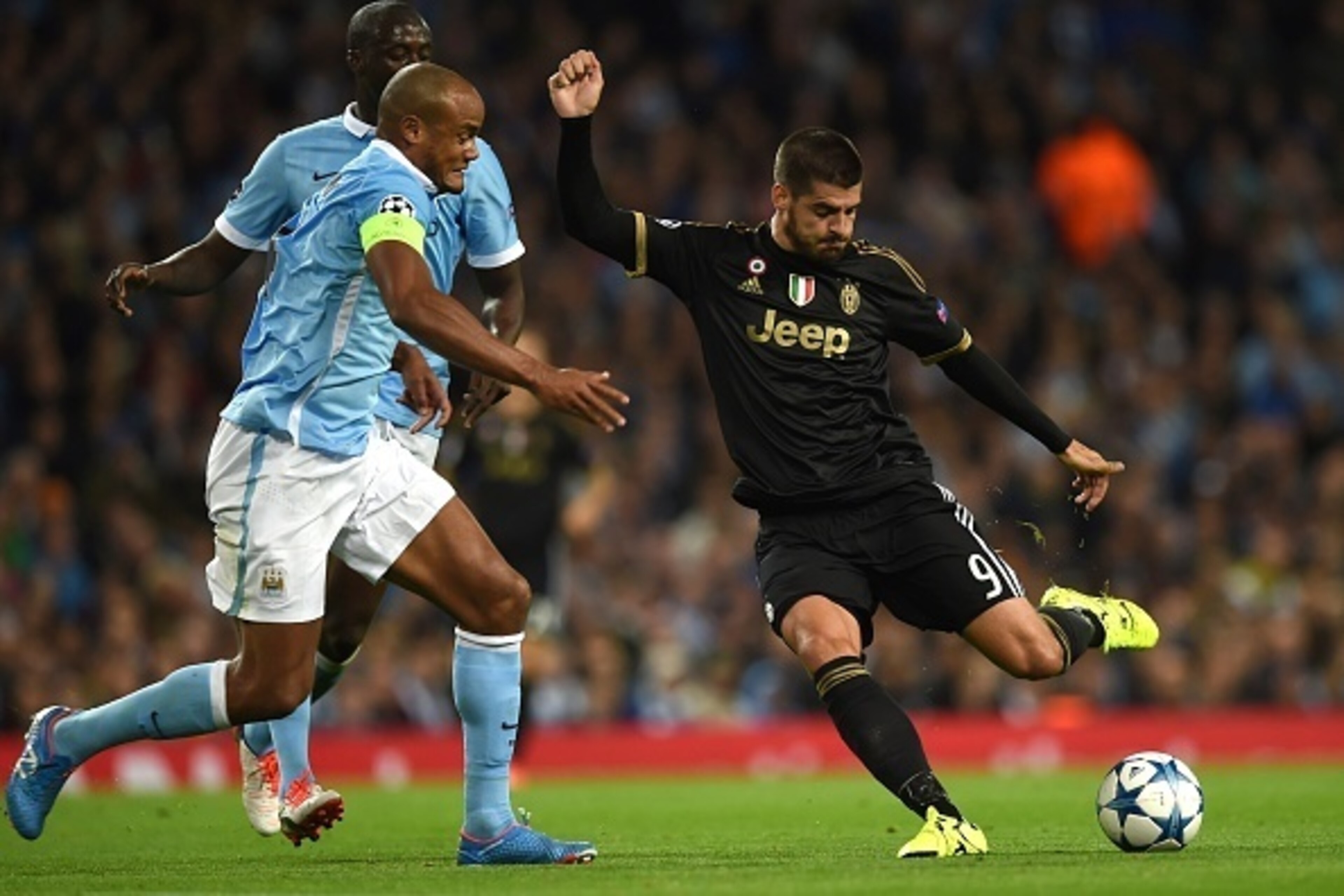 Juventus' forward from Spain Alvaro Morata (R) has a shot on goal past Manchester City's Belgian defender Vincent Kompany during a UEFA Champions League group stage football match between Manchester City and Juventus at the Etihad stadium in Manchester, n Juventus' forward from Spain Alvaro Morata (R) has a shot on goal past Manchester City's Belgian defender Vincent Kompany during a UEFA Champions League group stage football match between Manchester City and Juventus at the Etihad stadium in Manchester, n
