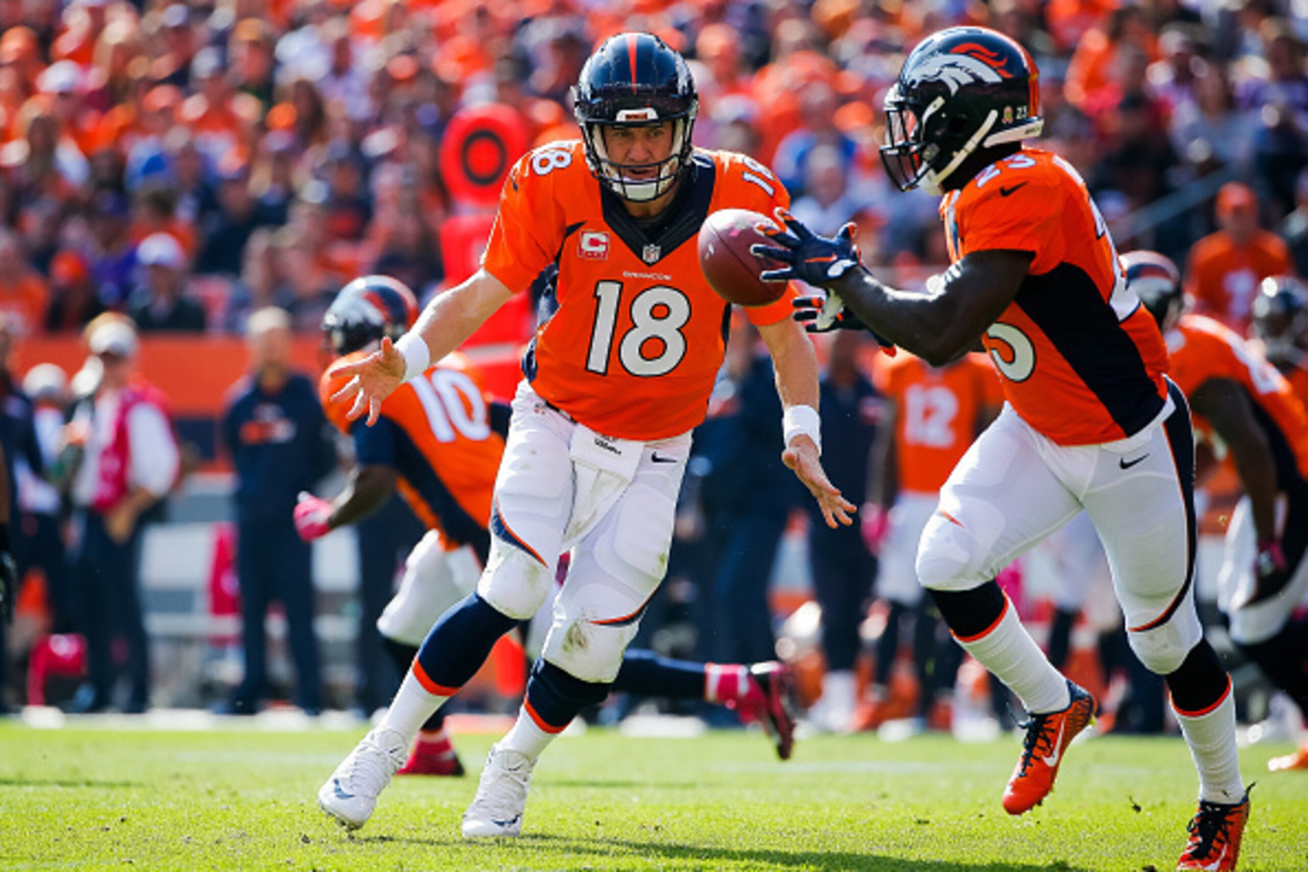 DENVER, CO - OCTOBER 4:  Quarterback Peyton Manning #18 of the Denver Broncos pitches the ball to Ronnie Hillman #23 on a play where Hillman would rush 72 yards for a touchdown in the second quarter of a game against the Minnesota Vikings at Sports Author