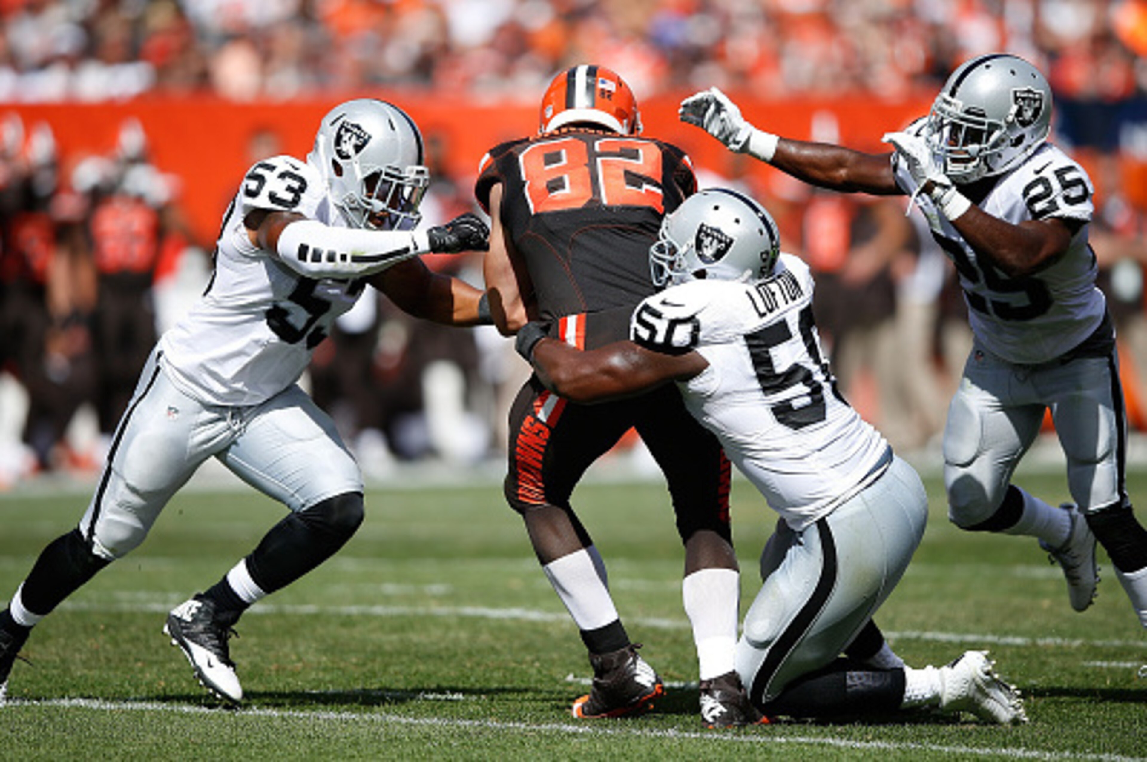 CLEVELAND, OH - SEPTEMBER 27:  Gary Barnidge #82 of the Cleveland Browns is stopped by the defense of Malcolm Smith #53, Curtis Lofton #50 and D.J. Hayden #25 of the Oakland Raiders during the second quarter at FirstEnergy Stadium on September 27, 2015 in