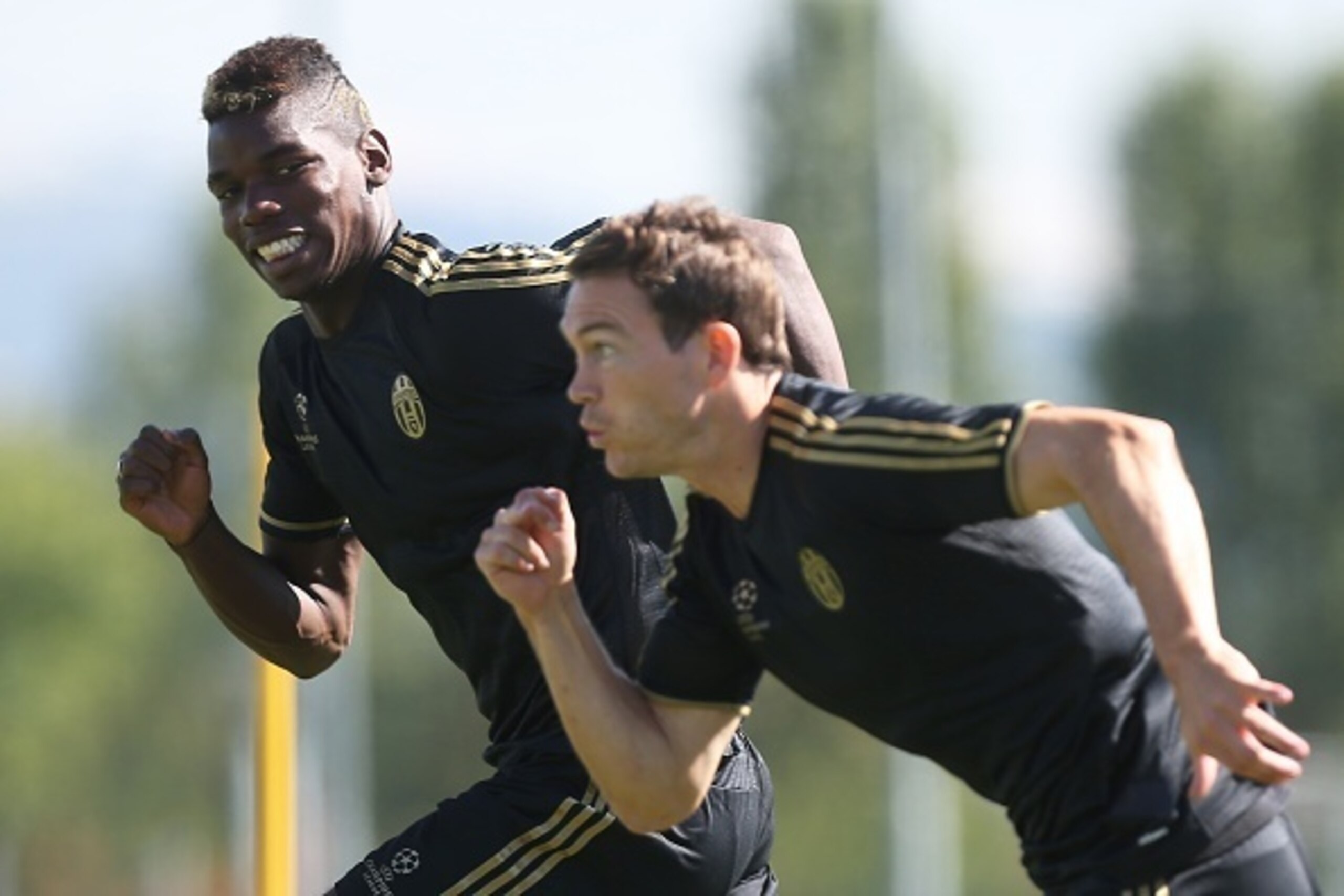 Juventus' French midfielder Paul Pogba (L) and Swiss defender Stephan Lichtsteiner take part in a training session on the eve of an UEFA Champions League football match against Manchester City on September 14, 2015 at the 'Juventus Training Center' in Vin Juventus' French midfielder Paul Pogba (L) and Swiss defender Stephan Lichtsteiner take part in a training session on the eve of an UEFA Champions League football match against Manchester City on September 14, 2015 at the 'Juventus Training Center' in Vin