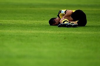 Dortmund's Armenian midfielder Henrikh Mkhitaryan lays injured on the pitch during the German first division Bundesliga football match Borussia Dortmund v SV Darmstadt 98, in Dortmund, western Germany, on September 27, 2015. AFP PHOTO / PATRIK STOLLARZ

R