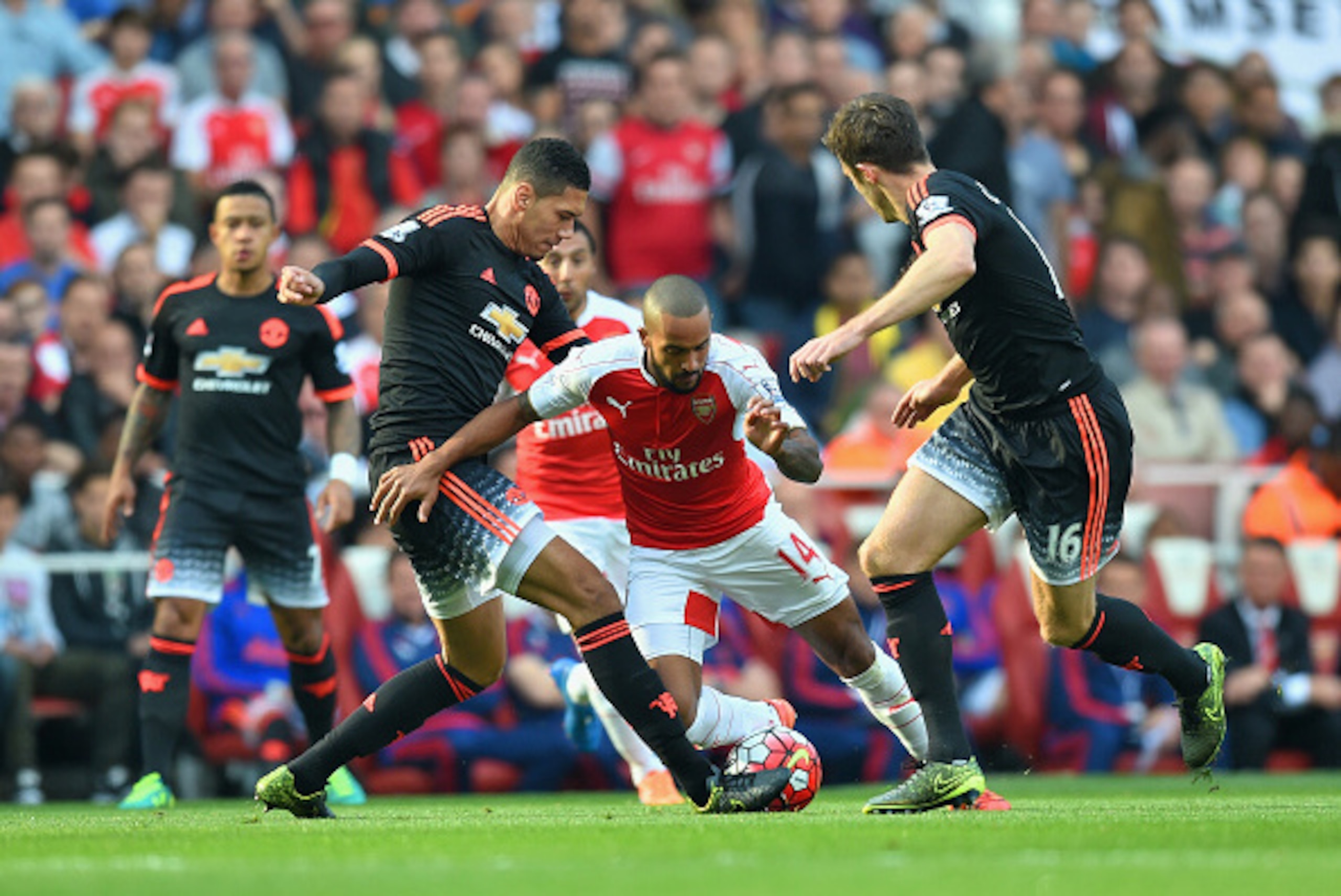 LONDON, ENGLAND - OCTOBER 04:  Theo Walcott of Arsenal is tackled by Chris Smalling of Manchester United during the Barclays Premier League match between Arsenal and Manchester United at Emirates Stadium on October 4, 2015 in London, England.  (Photo by M