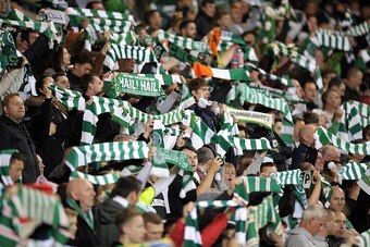 Celtic fans raise their scarves in the crowd before kick off in the UEFA Europa League group A football match between Celtic and Fenerbahce at Celtic Park in Glasgow, Scotland on October 1, 2015. The game finished 2-2. AFP PHOTO / ANDY BUCHANAN        (Ph