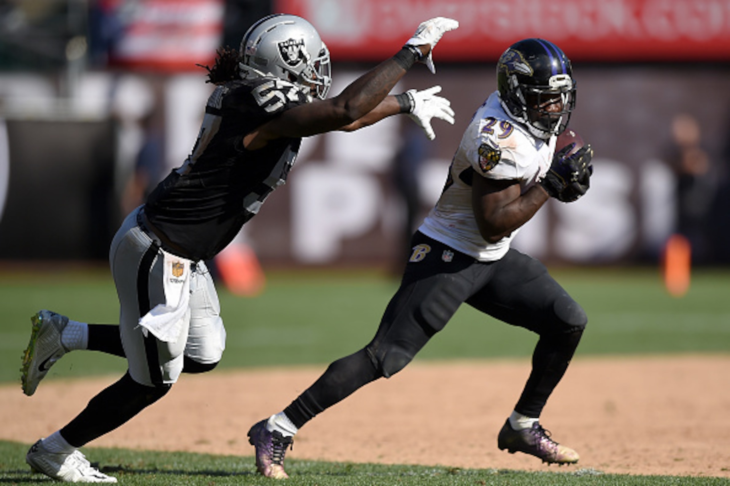 OAKLAND, CA - SEPTEMBER 20:  Justin Forsett #29 of the Baltimore Ravens carries the ball while being persued by Ray-Ray Armstrong #57 of the Oakland Raiders in the fourth quarter at the O.co Coliseum on September 20, 2015 in Oakland, California.  (Photo b