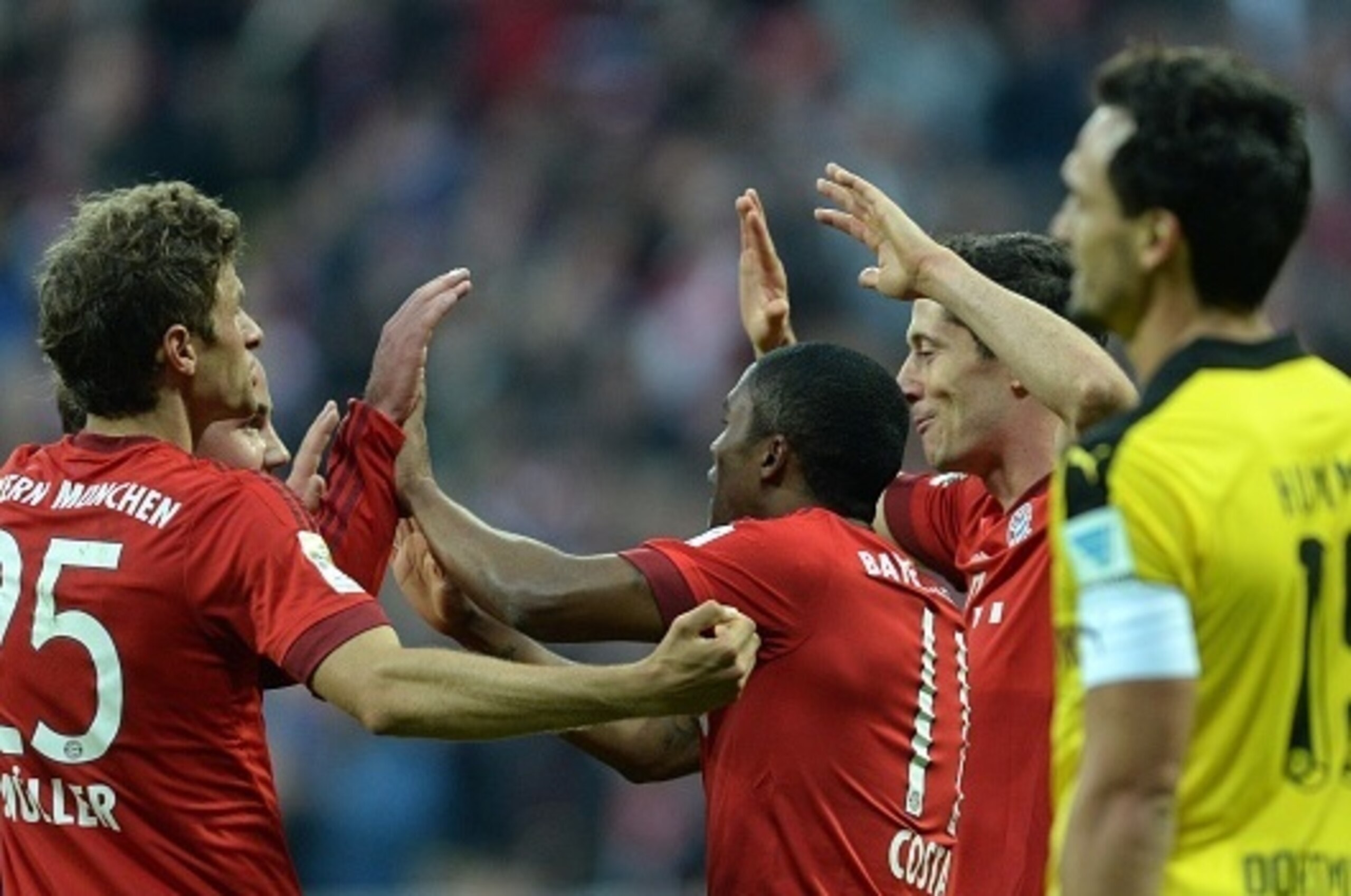 (L-R) Bayern Munich's striker Thomas Mueller, Bayern Munich's midfielder Mario Goetze, FC Bayern Munich's Brazilian midfielder Douglas Costa and FC Bayern Munich's Polish striker Robert Lewandowski celebrate after the third goal for Munich beside of Dortm