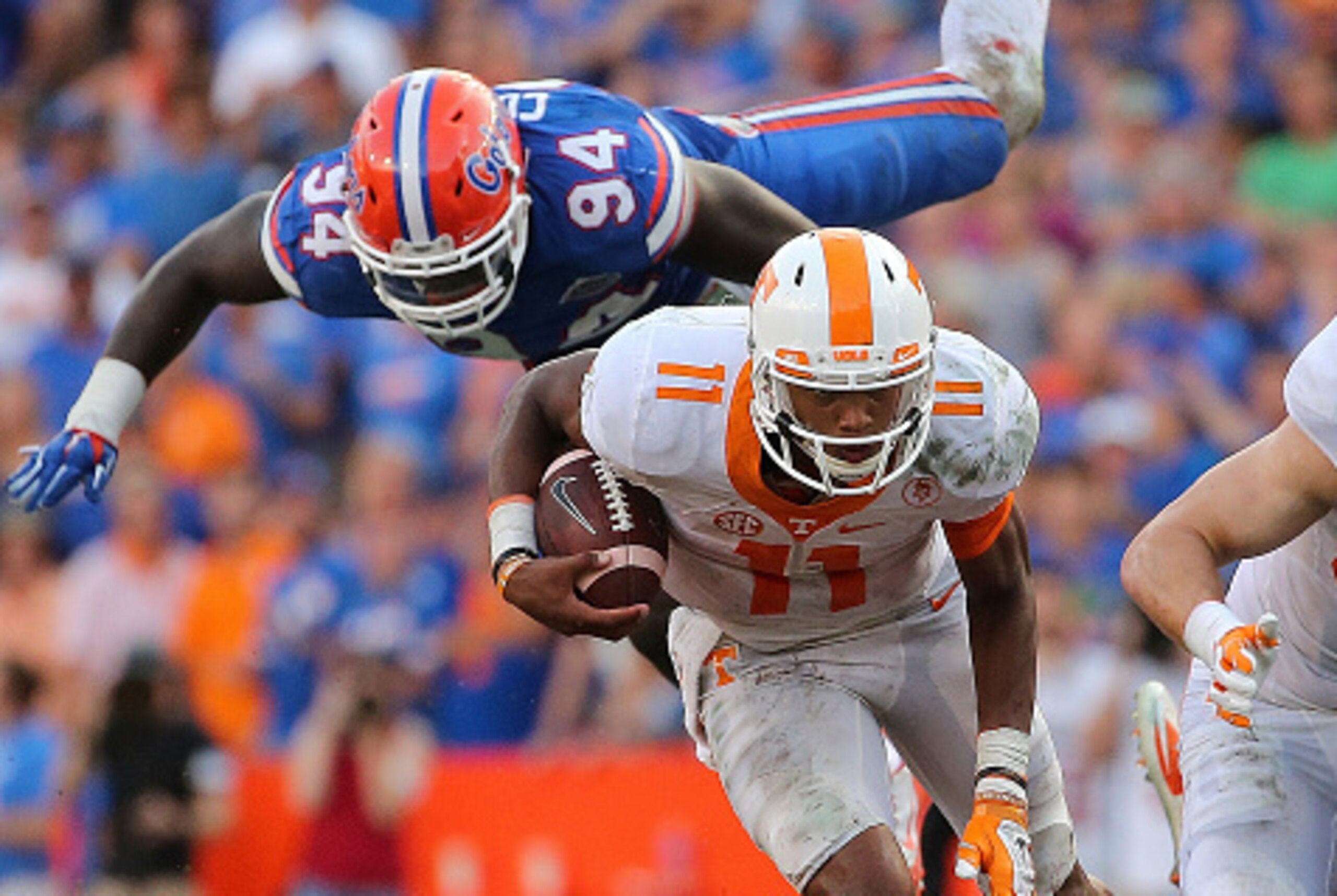 GAINESVILLE, FL - SEPTEMBER 26:  Joshua Dobbs #11 of the Tennessee Volunteers escapes a tckle from Bryan Cox #94 of the Florida Gators during a game  at Ben Hill Griffin Stadium on September 26, 2015 in Gainesville, Florida.  (Photo by Mike Ehrmann/Getty 