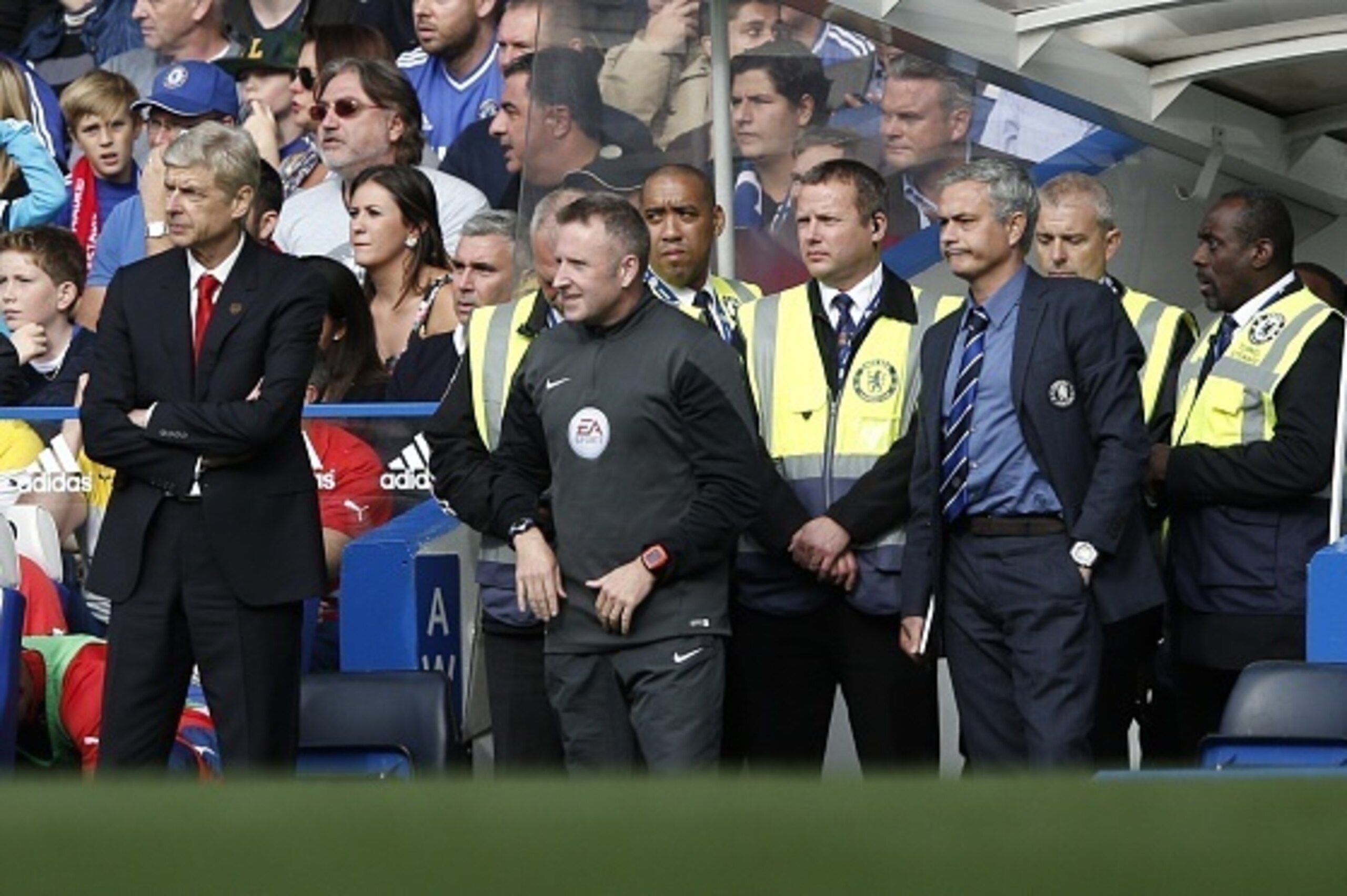 Arsenal's French manager Arsene Wenger (L) and Chelsea's Portuguese manager Jose Mourinho (R) watch the English Premier League football match between Chelsea and Arsenal at Stamford Bridge in London on October 5, 2014. Chelsea won the game 2-0. AFP PHOTO/