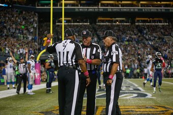 SEATTLE, WA - OCTOBER 05:  Referees confer after the ball was batted out of the end zone by outside linebacker K.J. Wright of the Seattle Seahawks following a fumble by wide receiver Calvin Johnson of the Detroit Lions in the fourth quarter at CenturyLink