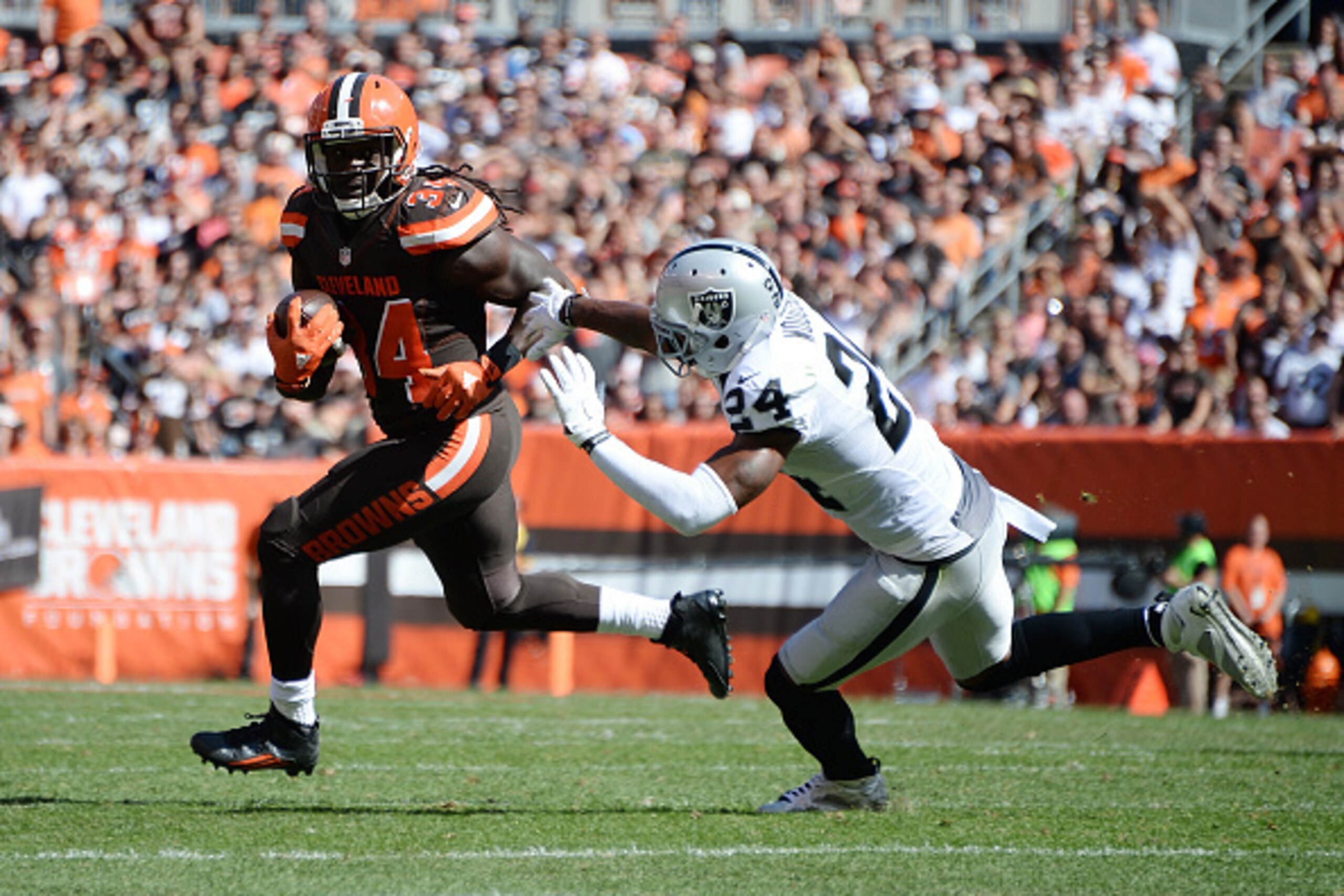 CLEVELAND, OH - SEPTEMBER 27:  Isaiah Crowell #34 of the Cleveland Browns avoids a tackle by Charles Woodson #24 of the Oakland Raiders and picks up a first down during the second quarter at FirstEnergy Stadium on September 27, 2015 in Cleveland, Ohio.  (