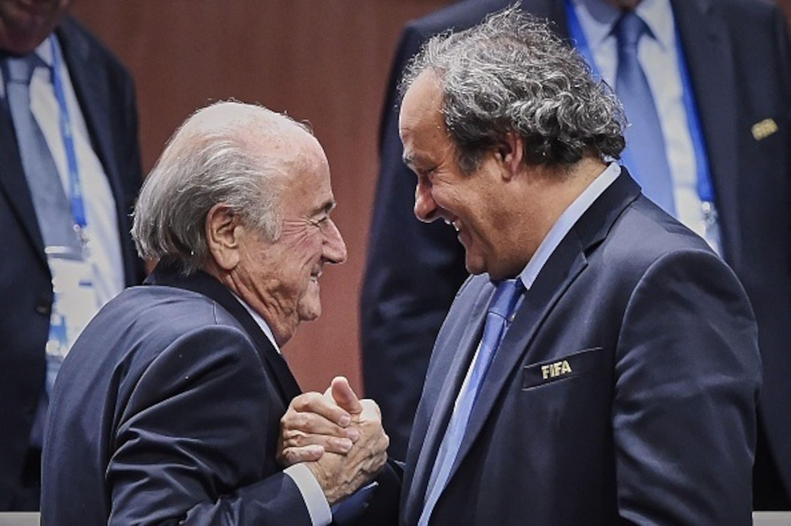 FIFA President Sepp Blatter (Foreground-L) shakes hands with UEFA president Michel Platini after being re-elected following a vote to decide on the FIFA presidency in Zurich on May 29, 2015. Sepp Blatter won the FIFA presidency for a fifth time after his 