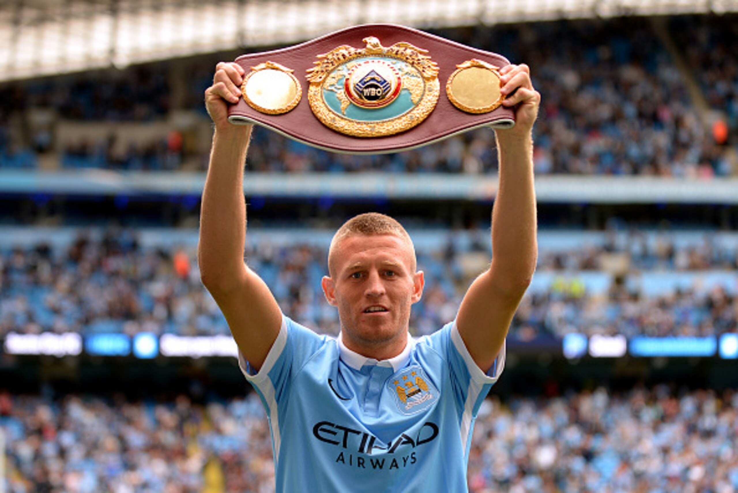 MANCHESTER, ENGLAND - AUGUST 29:  WBO World Lightweight champion Terry Flanagan lifts the champion belt prior to the Barclays Premier League match between Manchester City and Watford at Etihad Stadium on August 29, 2015 in Manchester, England.  (Photo by 
