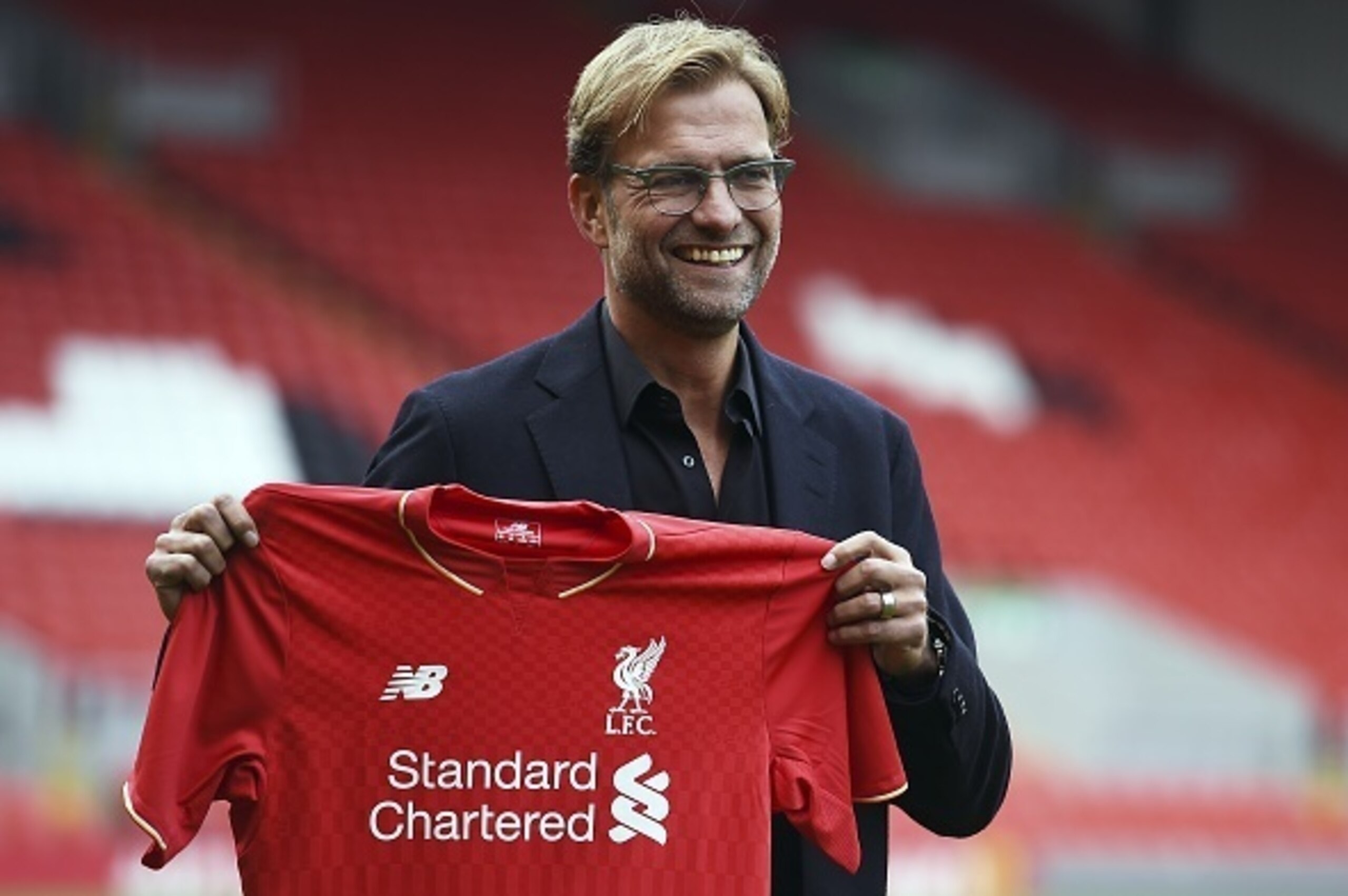 Liverpool's new German manager Jurgen Klopp poses with a team jersey after a press conference to announce his new appointment at Anfield in Liverpool, northwest England, on October 9, 2015. Klopp described his job as 'the biggest challenge' in world footb