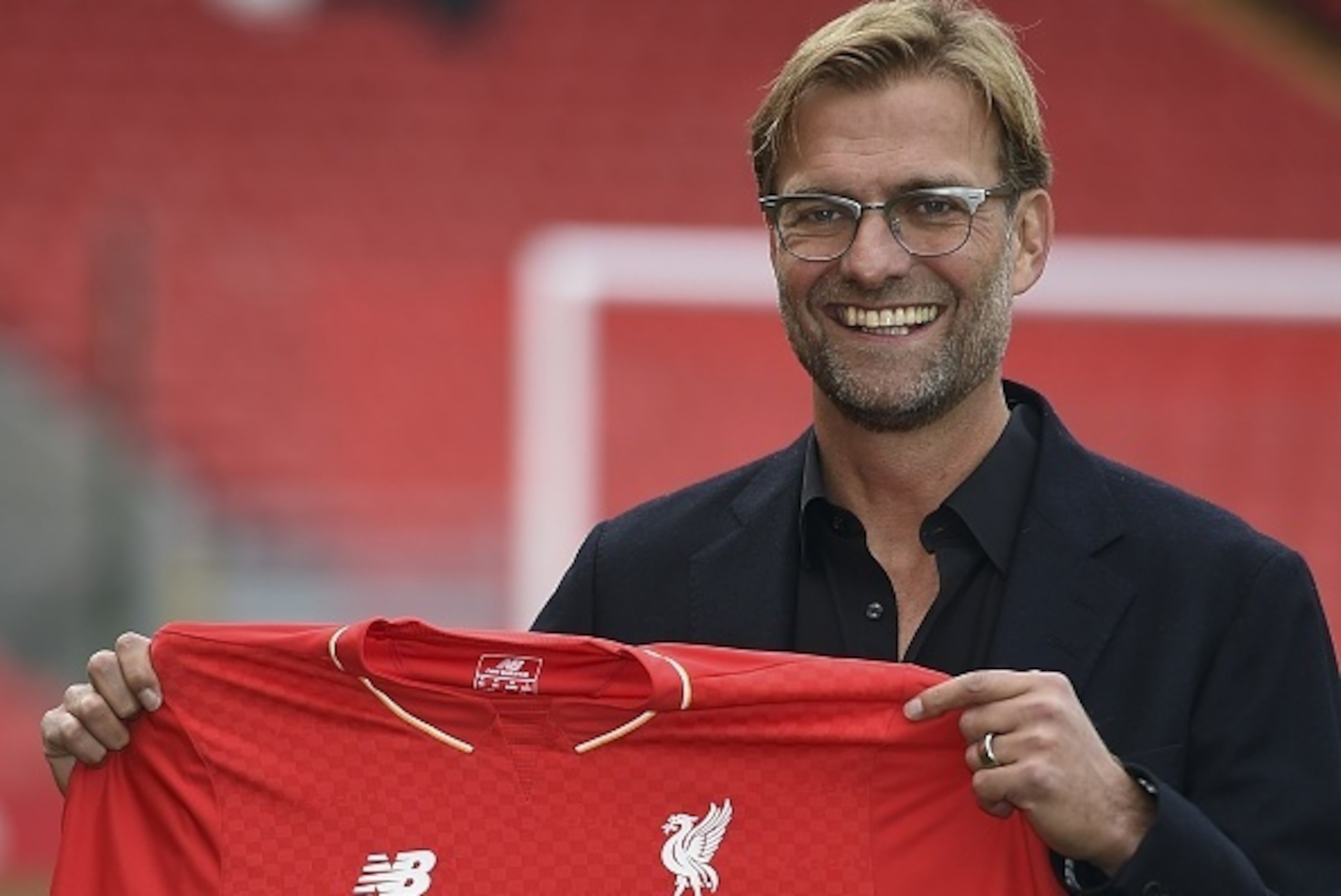 Liverpool's new German manager Jurgen Klopp poses with a team jersey after a press conference to announce his new appointment at Anfield in Liverpool, northwest England, on October 9, 2015. Klopp described his job as 'the biggest challenge' in world footb