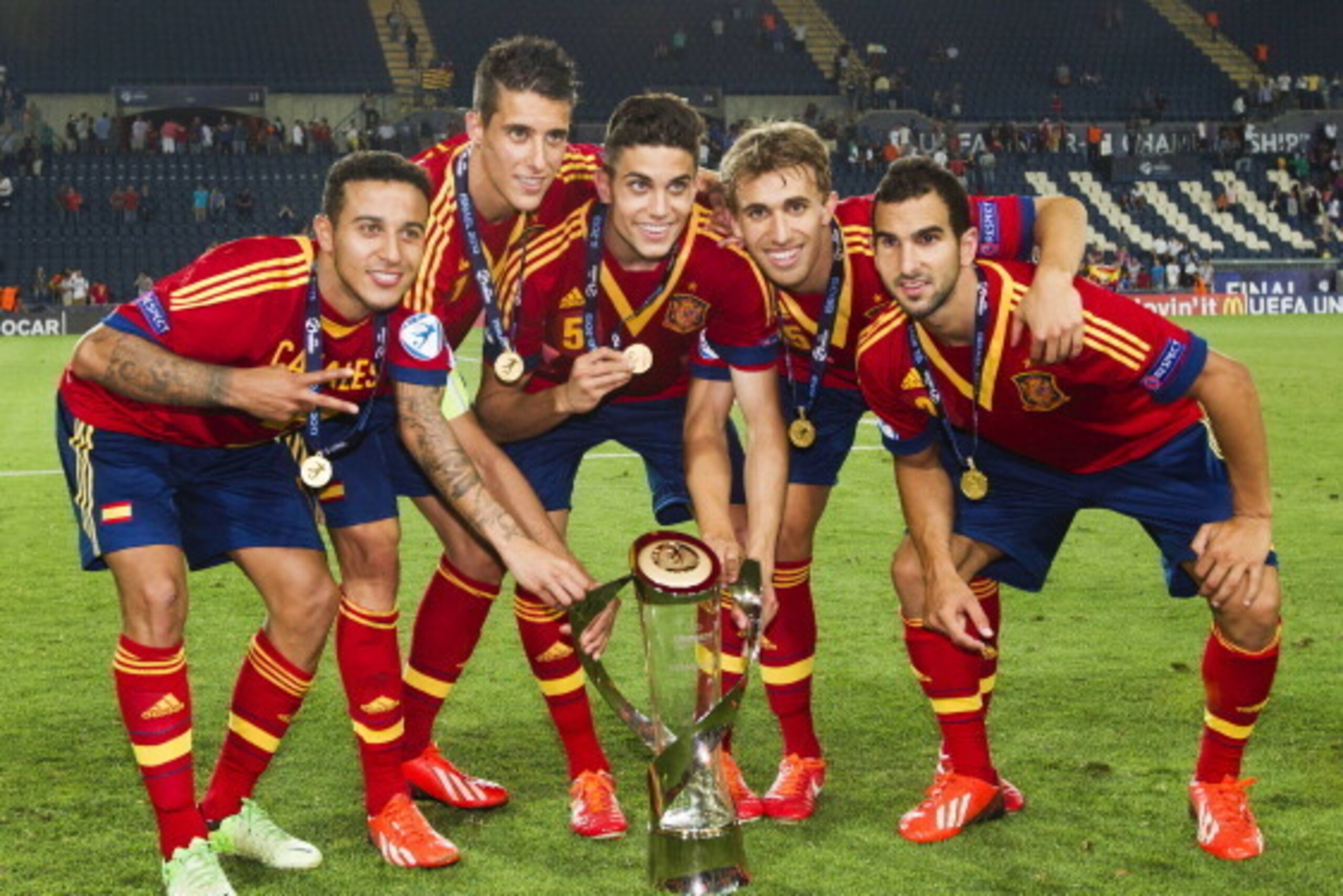 (L-R) Spain's midfielder Thiago Alcantara, forward Cristian Tello and defenders Marc Bartra, Marc Muniesa and Martin Montoya celebrate with the trophy after winning their 2013 UEFA U-21 Championship football match against Italy at Teddy Stadium in Jerusal