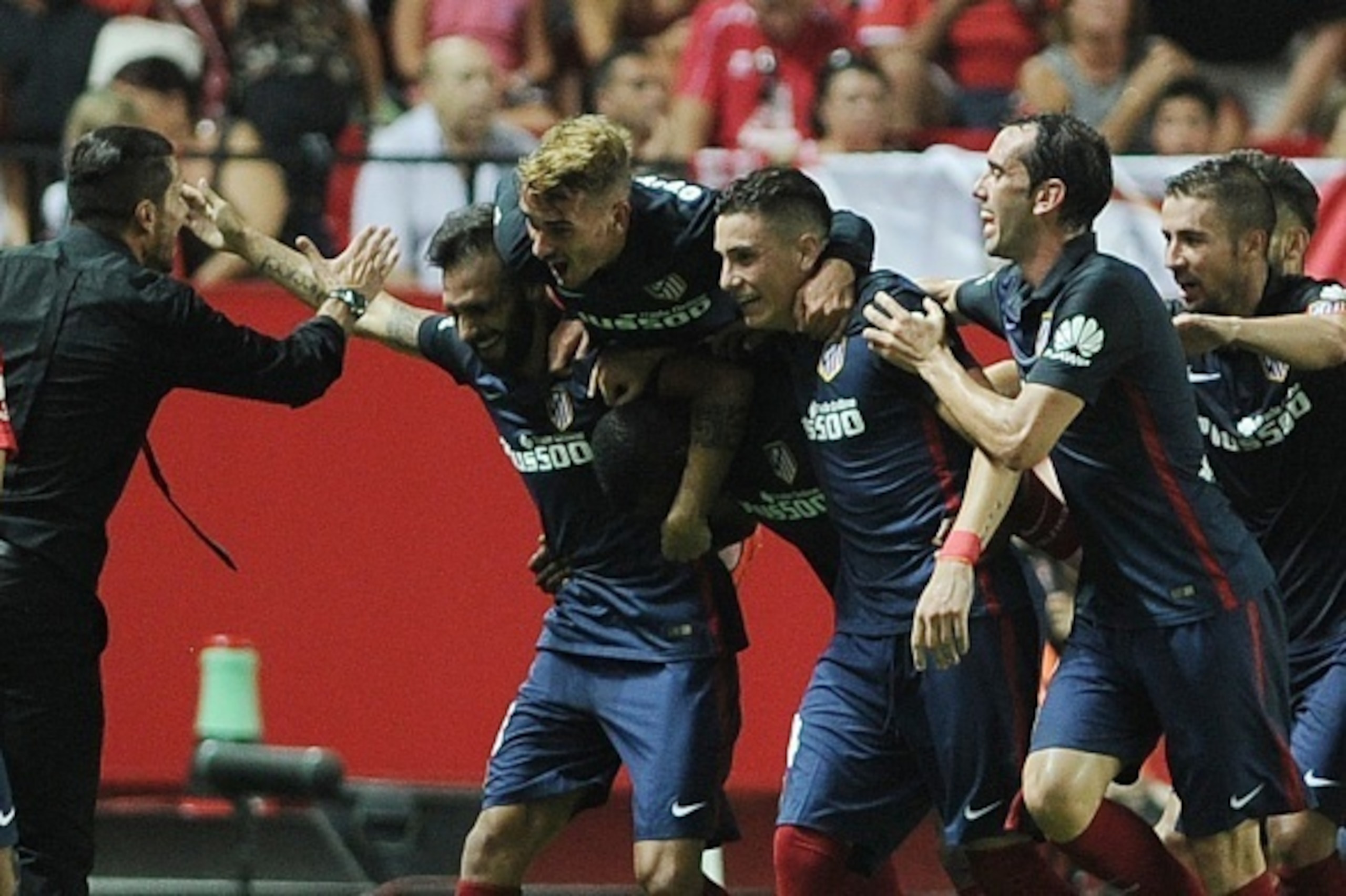 Atletico Madrid's Argentinian coach Diego Simeone (L) celebrates with his team after Atletico Madrid's Colombian forward Jackson Martínez scored a goal during the Spanish league football match Sevilla FC vs Club Atletico de Madrid at the Ramon Sanchez Piz