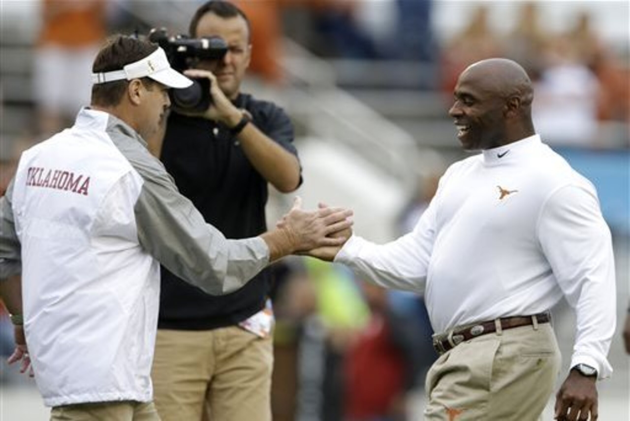Oklahoma coach Bob Stoops (left) and Texas coach Charlie Strong highly respect one another, but both are fighting for the same recruits around the Texas and Oklahoma areas.