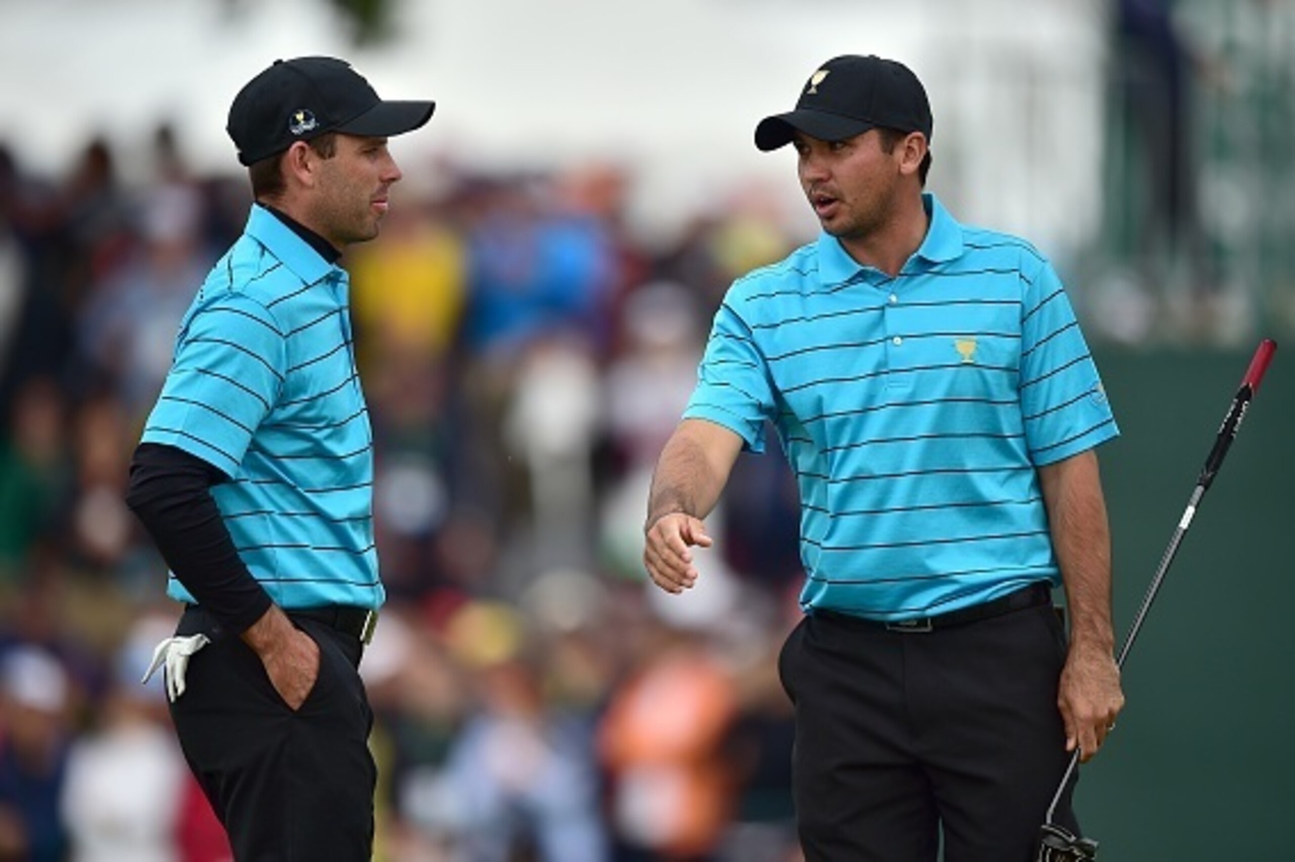 Jason Day of Australia (R) talks with Charl Schwartzel of South Africa (L) on the 18th hole during the round three foursome matches of the 2015 Presidents Cup at the Jack Nicklaus Golf Club in Incheon, west of Seoul, on October 10, 2015.     AFP PHOTO / J
